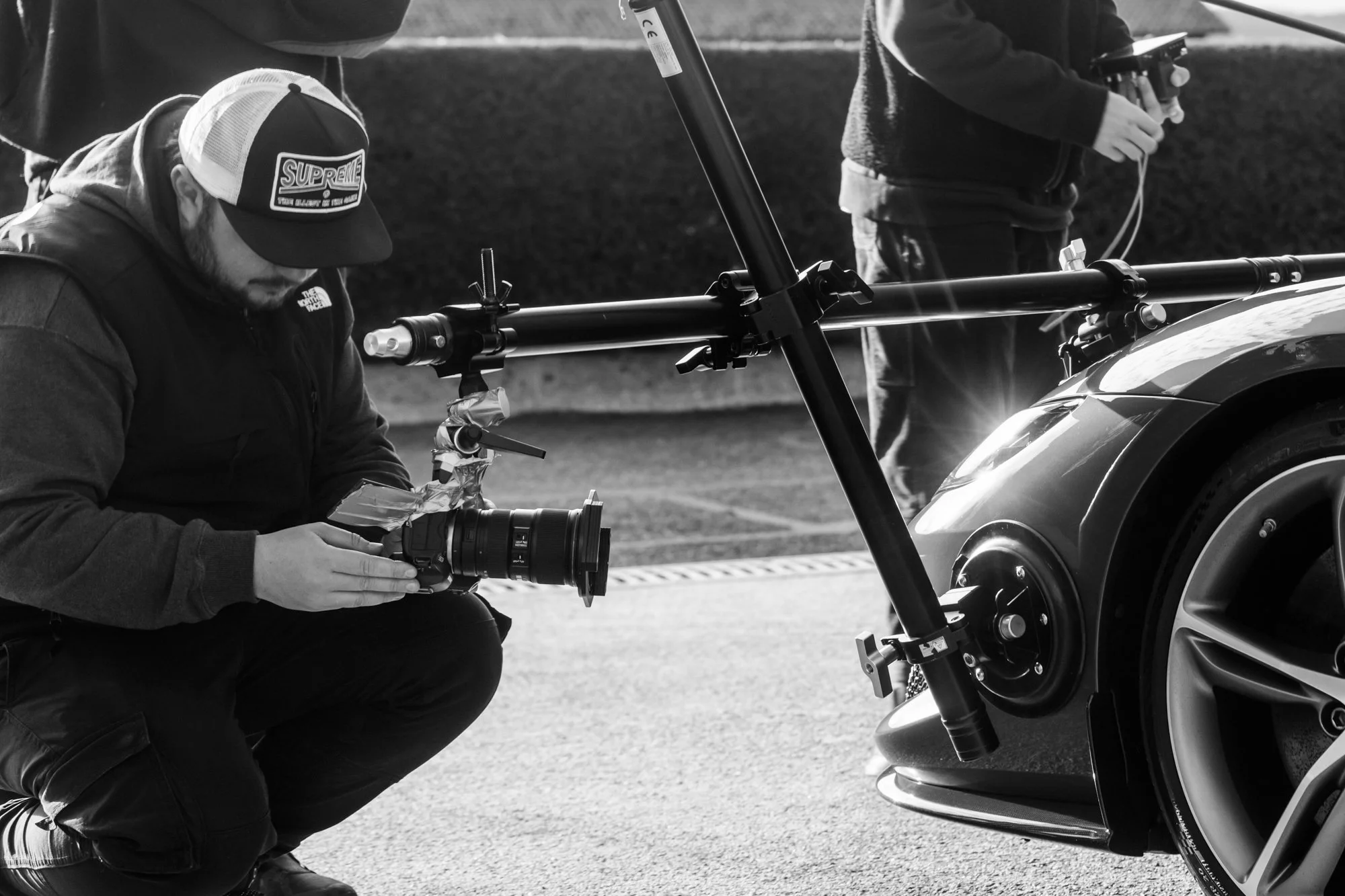 Un homme utilisant un stabilisateur pour caméra pour filmer une voiture.