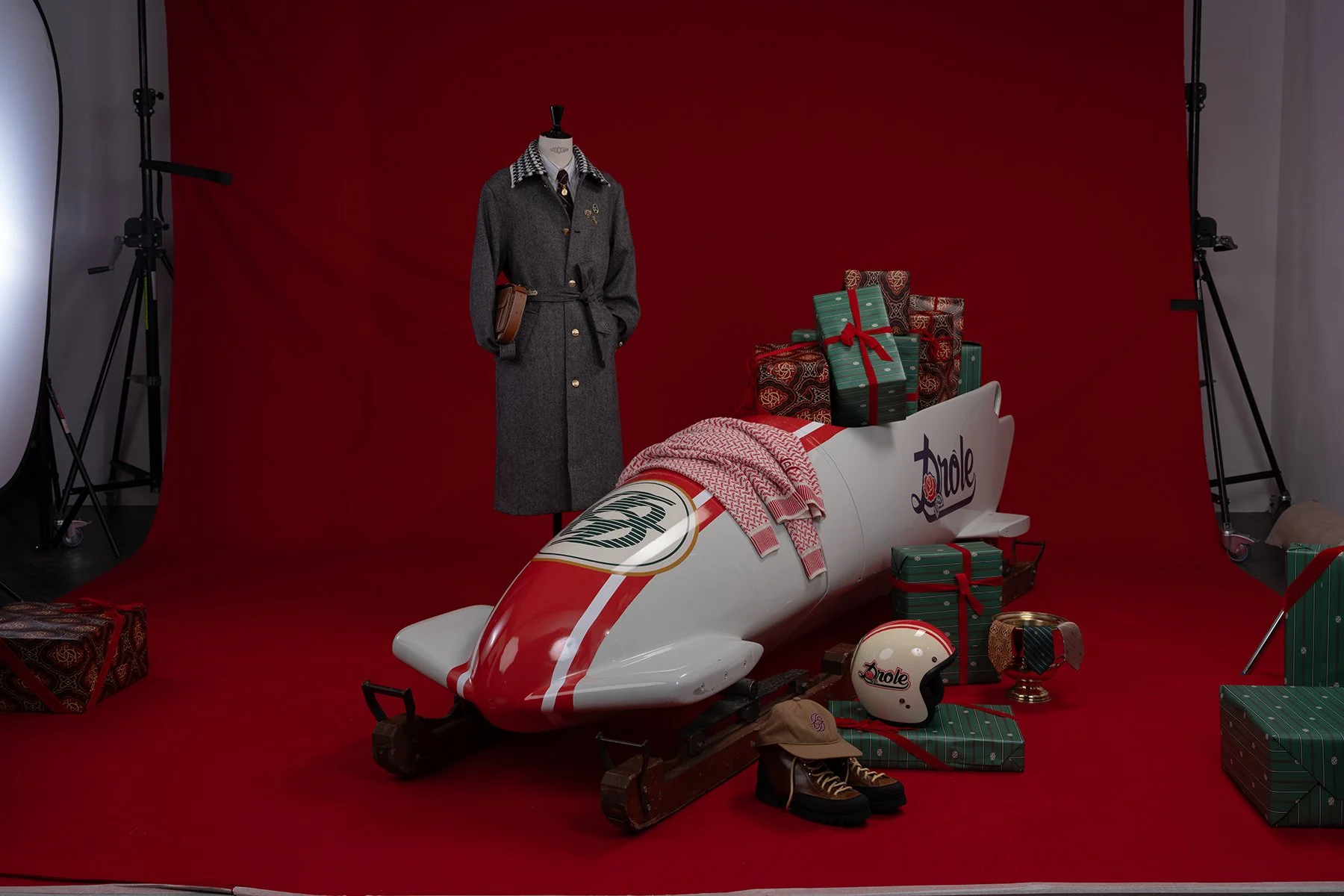Véhicule de ski décoré avec des cadeaux et vêtements de Noël, fond rouge, équipement de photographie