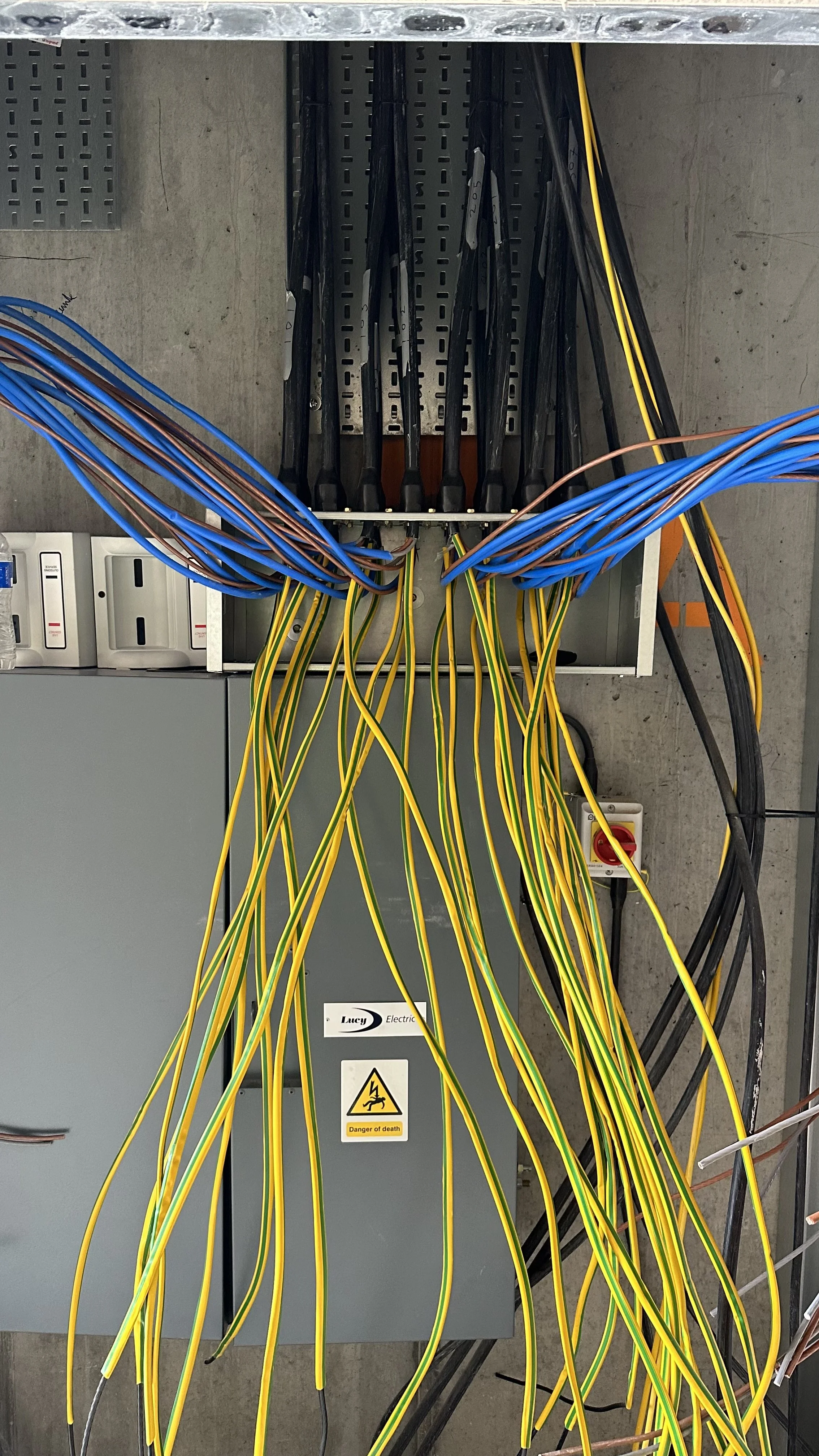 Electrical wiring and control panel with numerous yellow, blue, and black wires connected to various terminals."