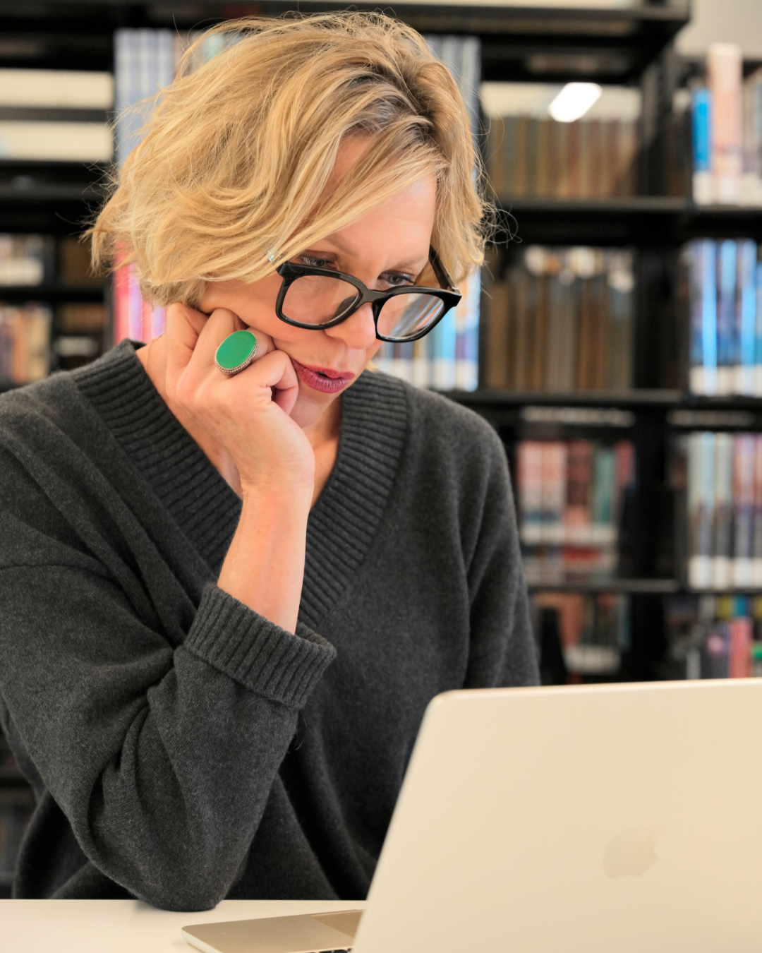 Brooke Hardie makes the law accessible. Here she is, a woman with short blonde hair and glasses looking at a laptop in a library.