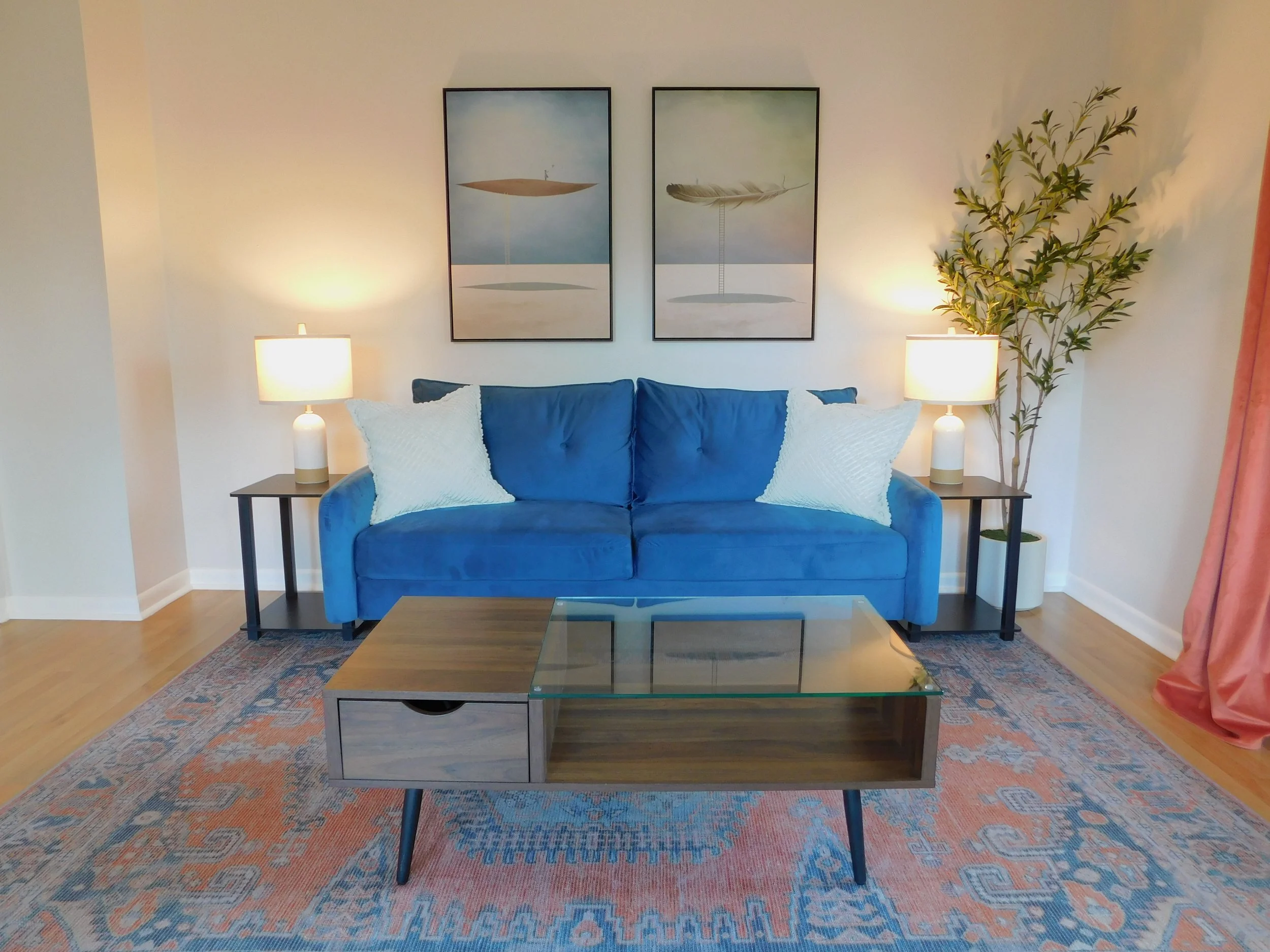 Suite A therapy setup with blue couch, layered lighting, modern artwork, and welcoming design that fosters community over coworking.