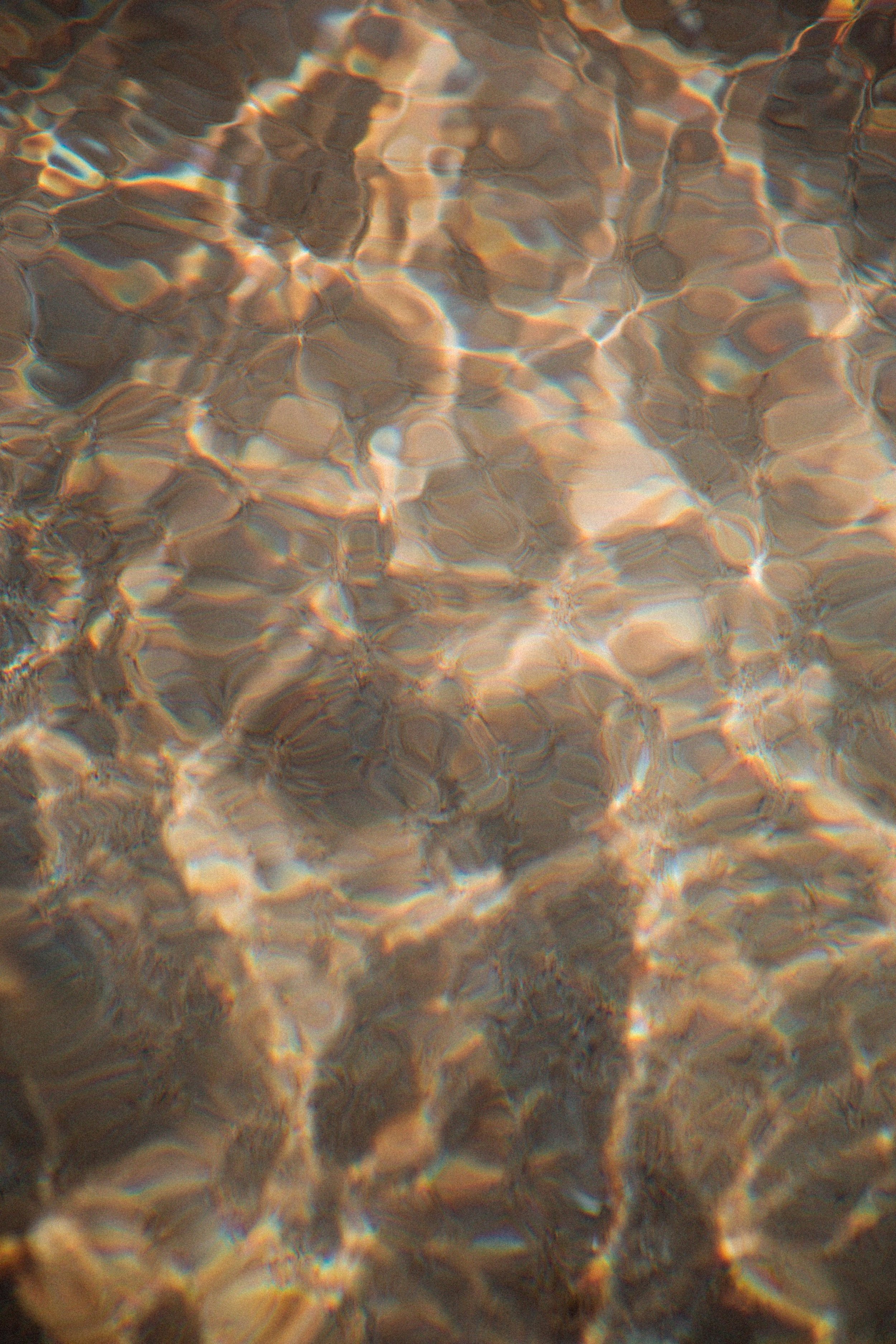 Light rippling across clear water, symbolizing the values that guide Luzia’s boutique therapy office spaces.