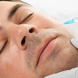 Close-up of a man receiving a cosmetic injection on his cheek