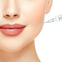 Close-up of a woman receiving a cosmetic injection near her lips.