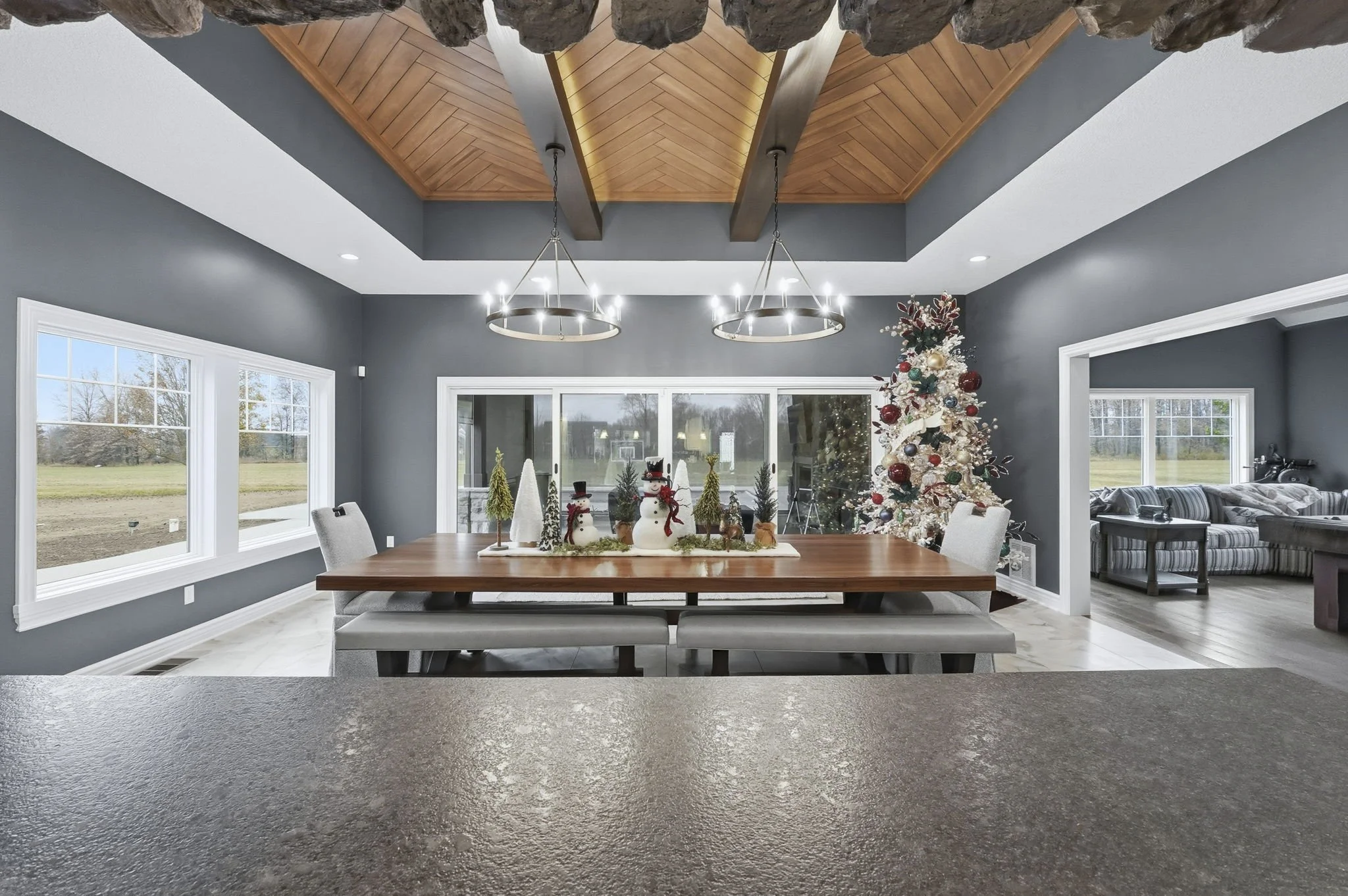 A decorated dining room with a Christmas tree and snowman decorations on the table.