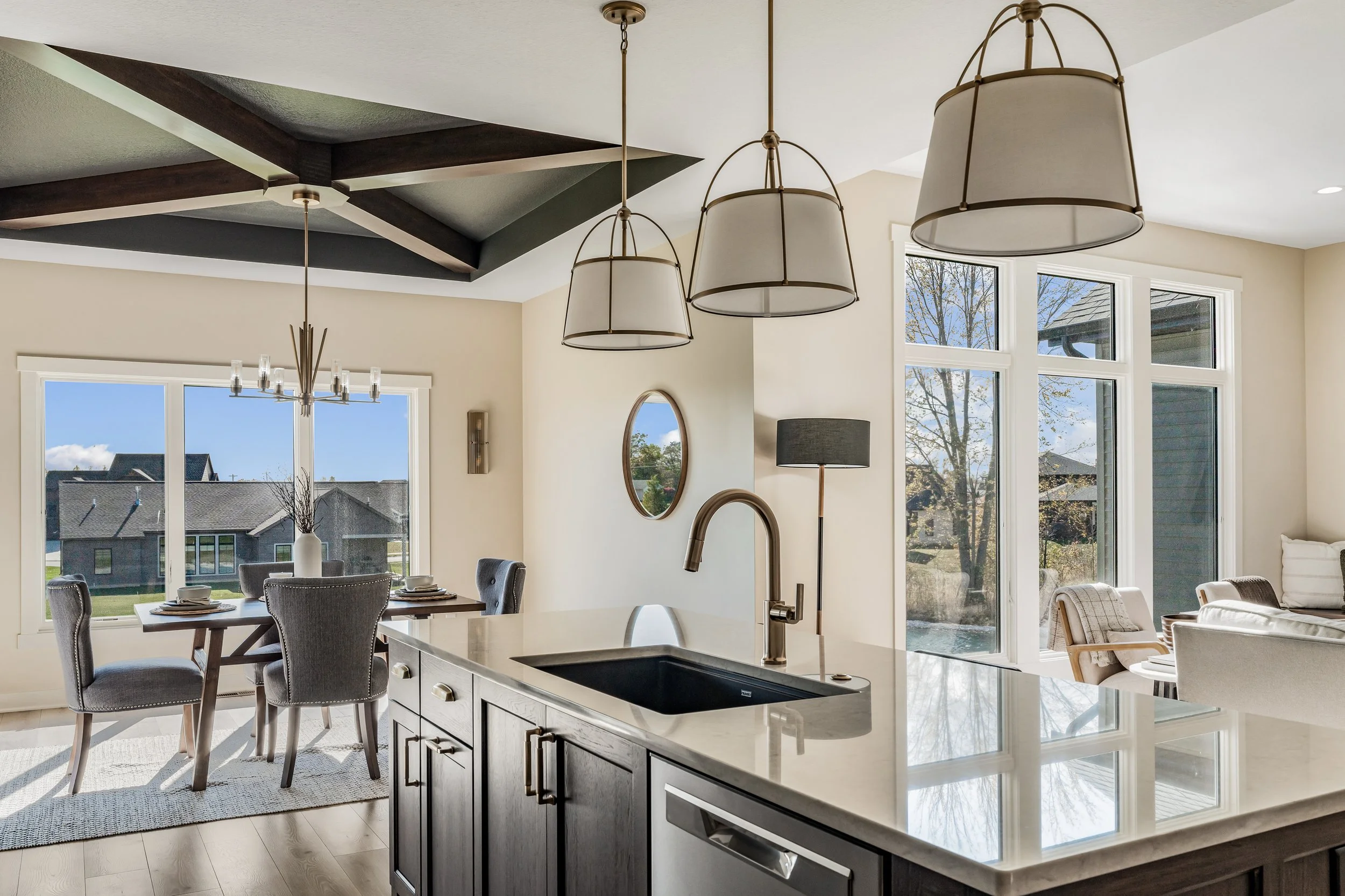 Modern kitchen with an island, pendant lights, and large windows providing natural light.