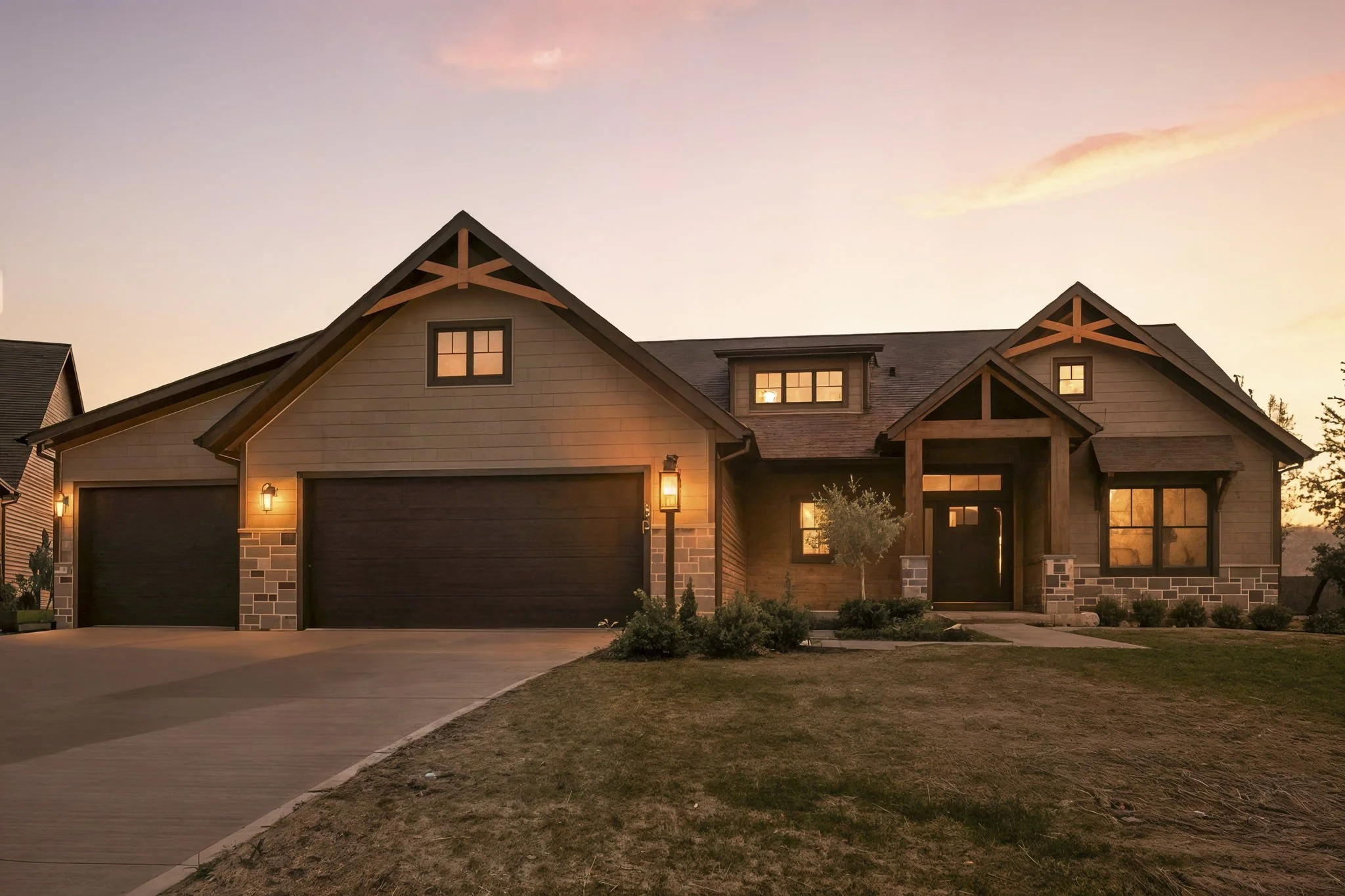 A modern house with a two-car garage, front yard, and decorative porch at sunset.