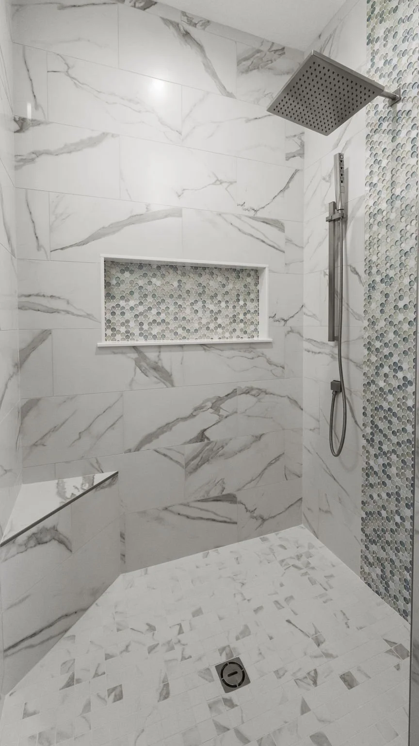 Modern shower with large marble tiles, a built-in niche with small mosaic tiles, a rainfall showerhead, and a handheld shower.
