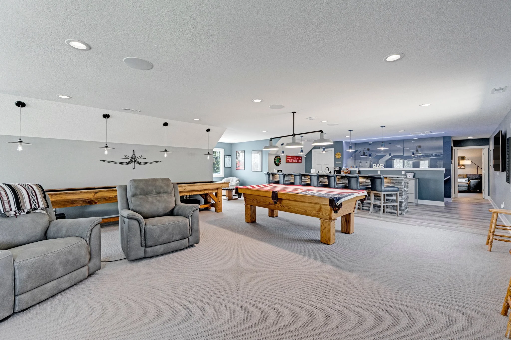 Spacious basement with seating area, foosball table, bar, and game room.