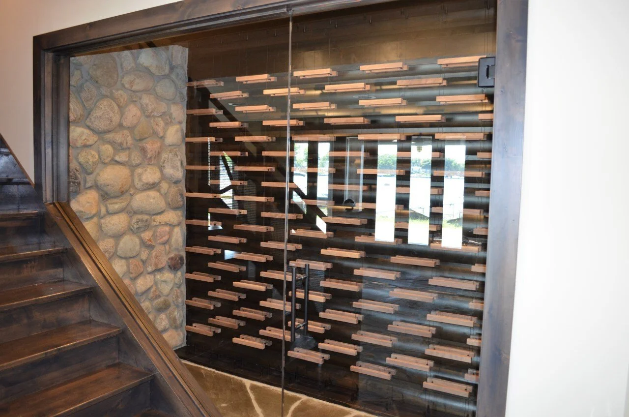 Interior view of a staircase and a glass wall with a wooden, geometric decorative partition inside a building.