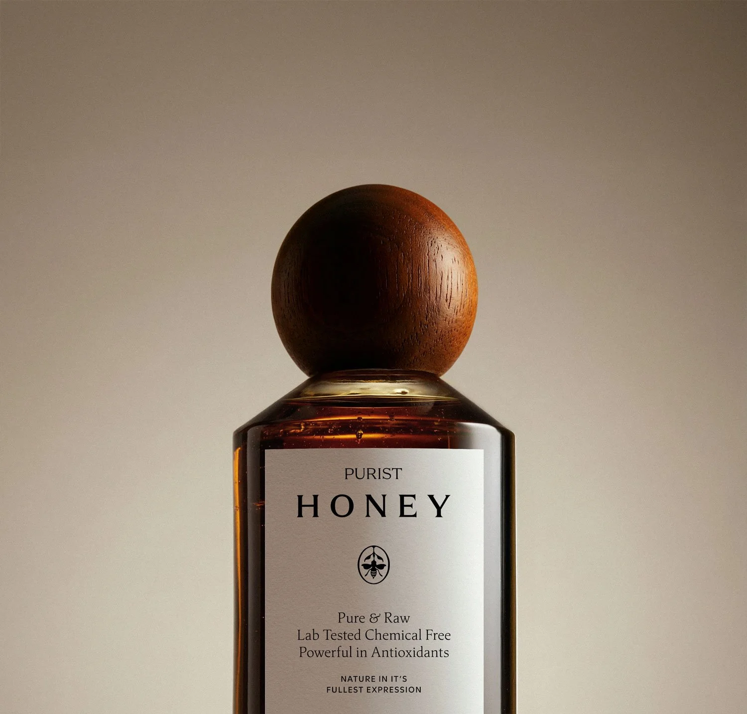 Purist Honey bottle and label up close on a cream background