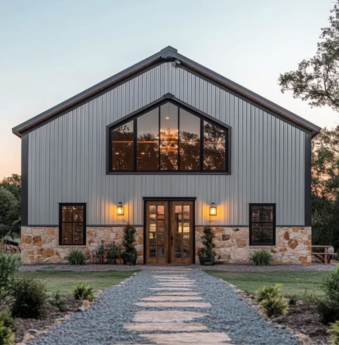 A modern two-story house with metal siding, stone foundation, large upper windows, wooden front door, and landscaped front yard with a stone pathway.