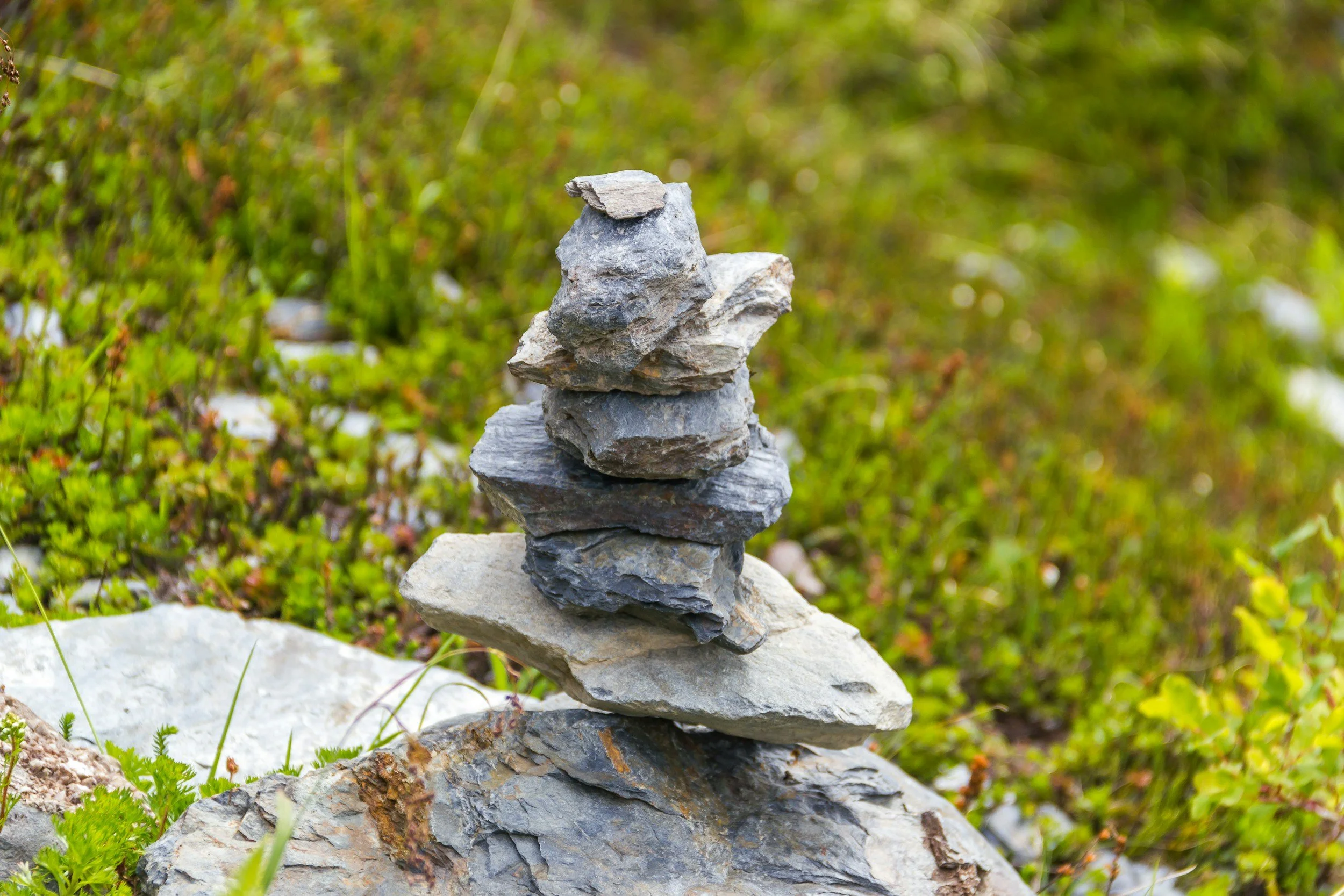 Ein Steinstapel in der Natur. Coaching in der Natur schafft neue Perspektiven und persönliche Entwicklung.
