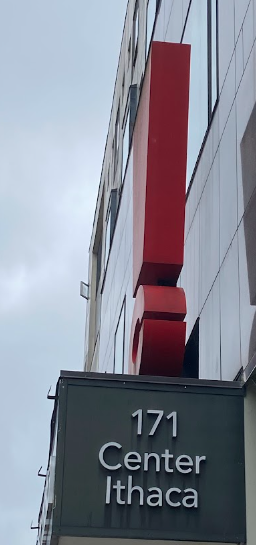 Photo of a building with a sign that reads '171 Center Ithaca' and a tall red structure attached to the building.