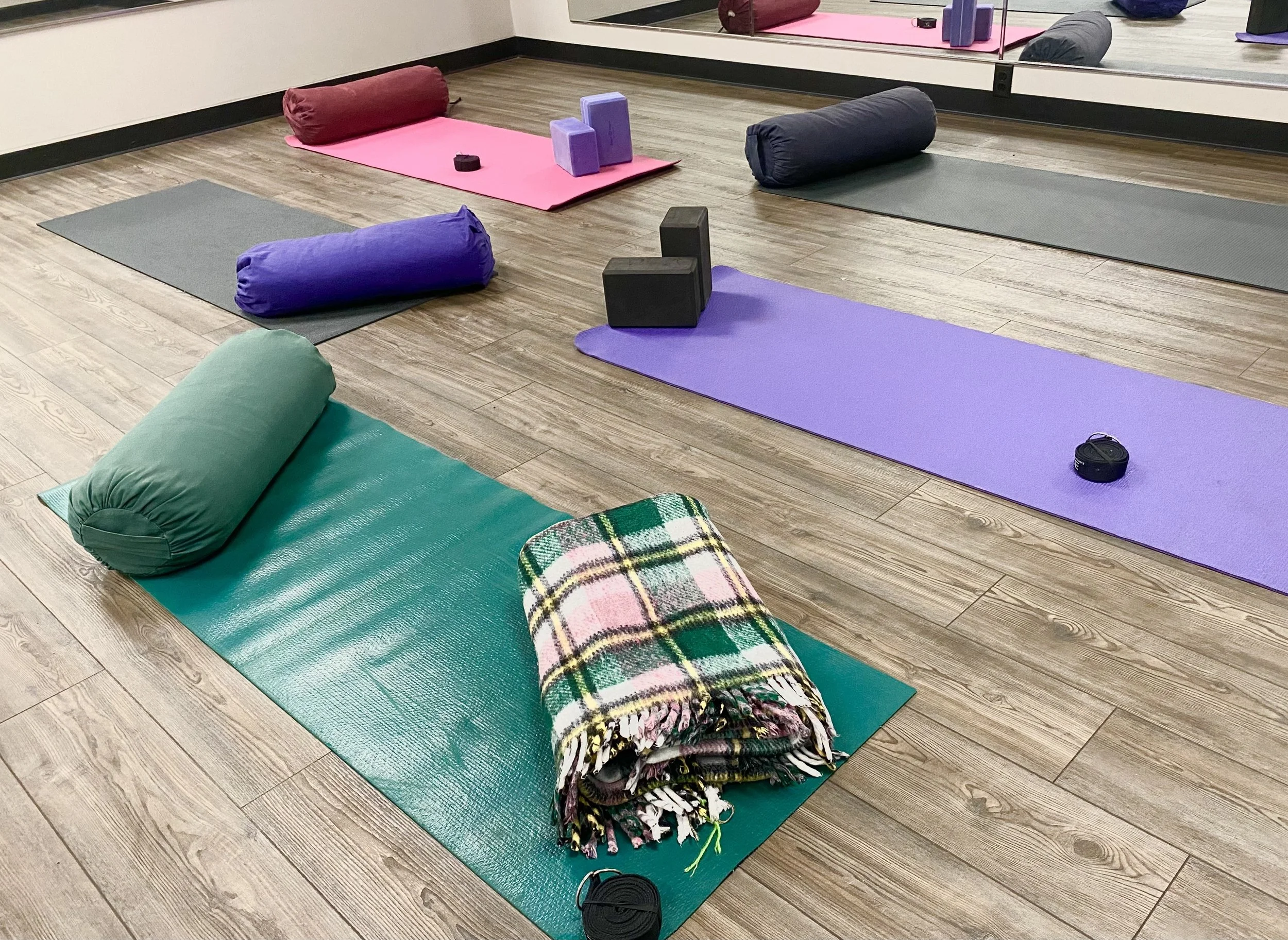 Yoga mats and props arranged on the floor at the gym.