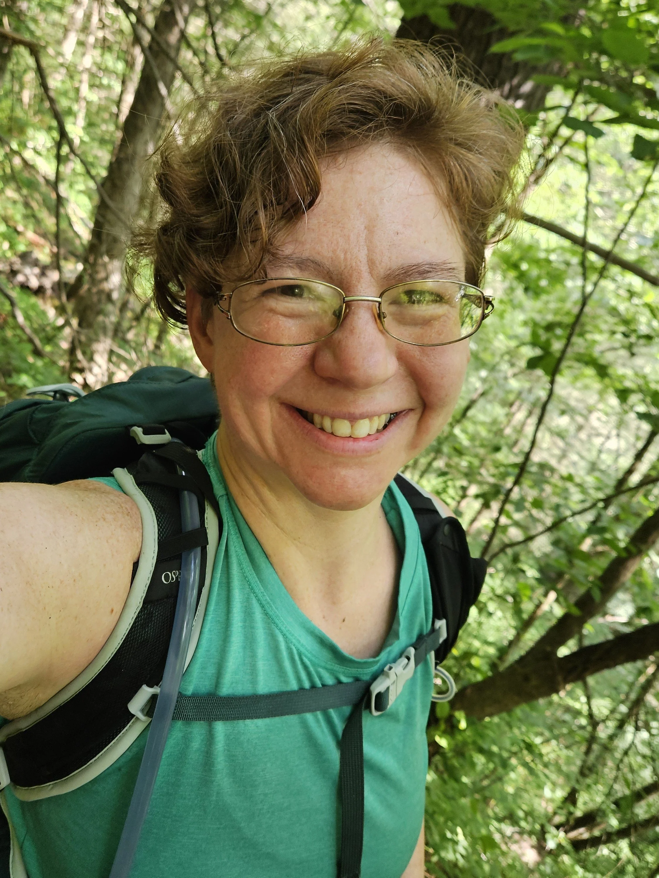 Instructor Sarah, hiking in woods, smiling