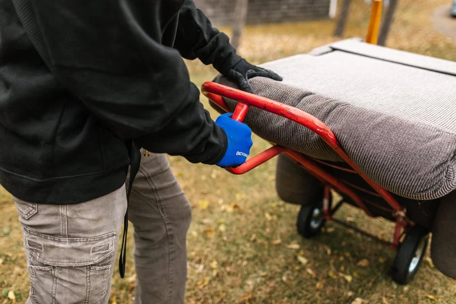 Junk Removal Expert hauling a recliner on a dollie