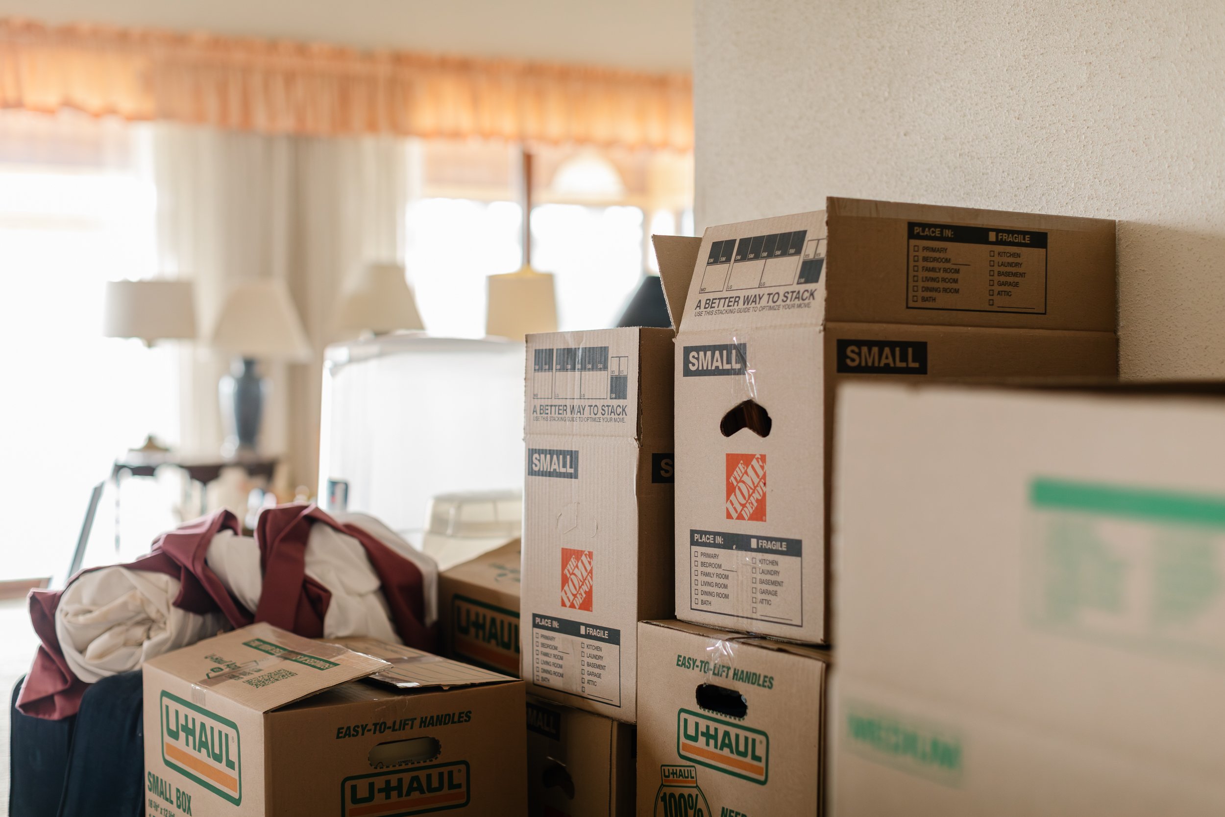Packed up boxes stacked against a wall in a home