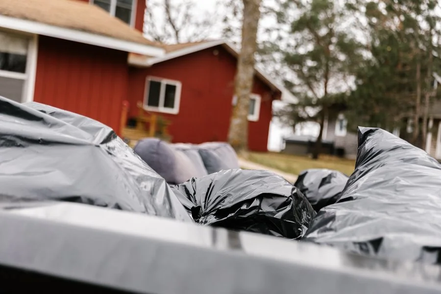 Dump trailer filled with black garbage bags