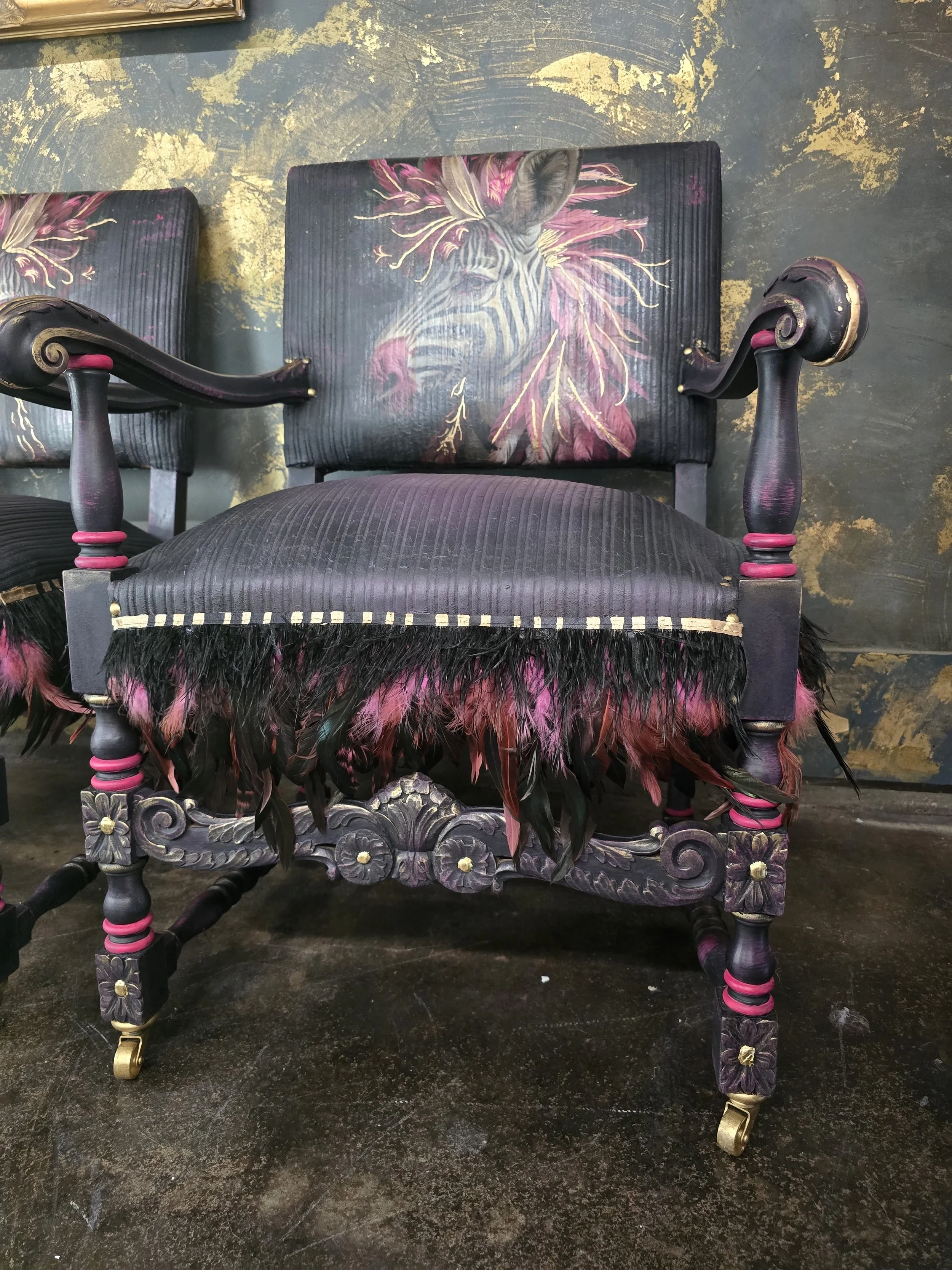 Decorative chair with painted zebra face and leaf design on the backrest, featuring black and pink feathered trim on the seat and ornate floral details on the legs.