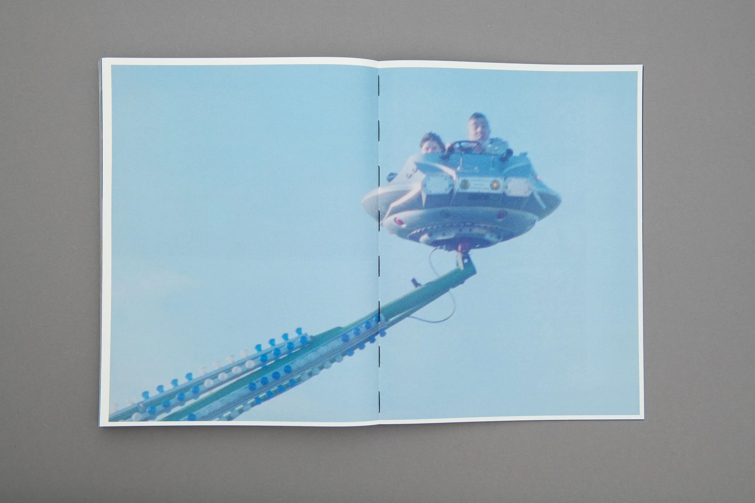 Due persone su un'attrazione di luna park con una struttura a forma di navicella spaziale in aria.