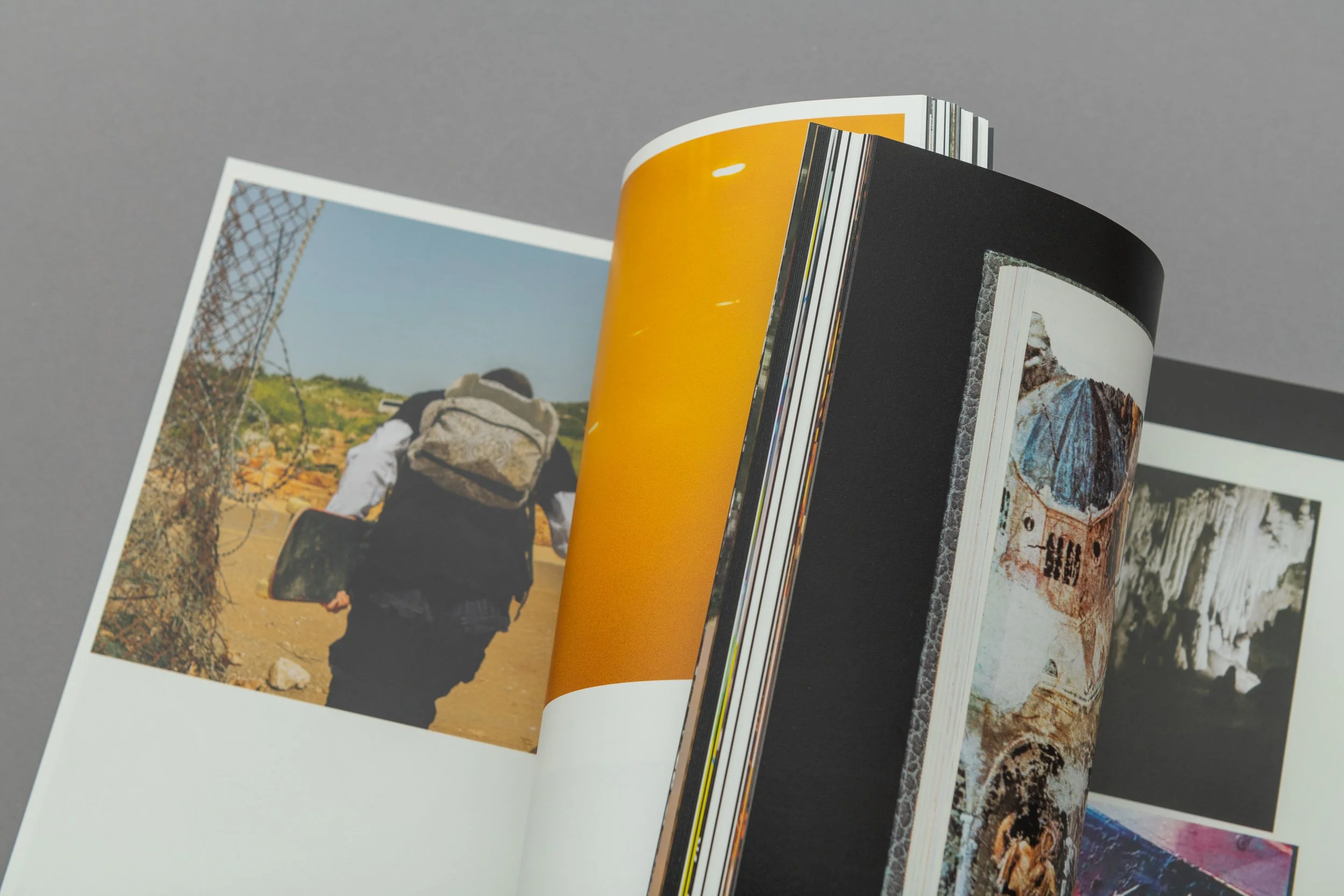 Un libro aperto con foto di una persona con zaino che cammina su un sentiero di terra e una copertina di uno dei dettagli del libro.