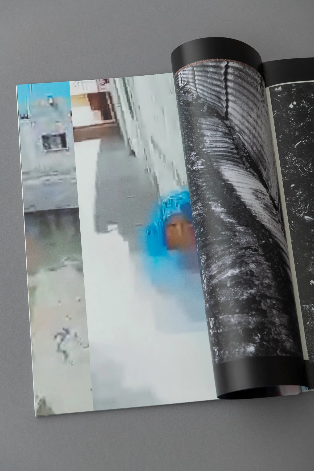 Pagina di un libro aperto con fotografie di scene urbane e naturali, tra cui un muro, un fiume e una strada con un veicolo blu.