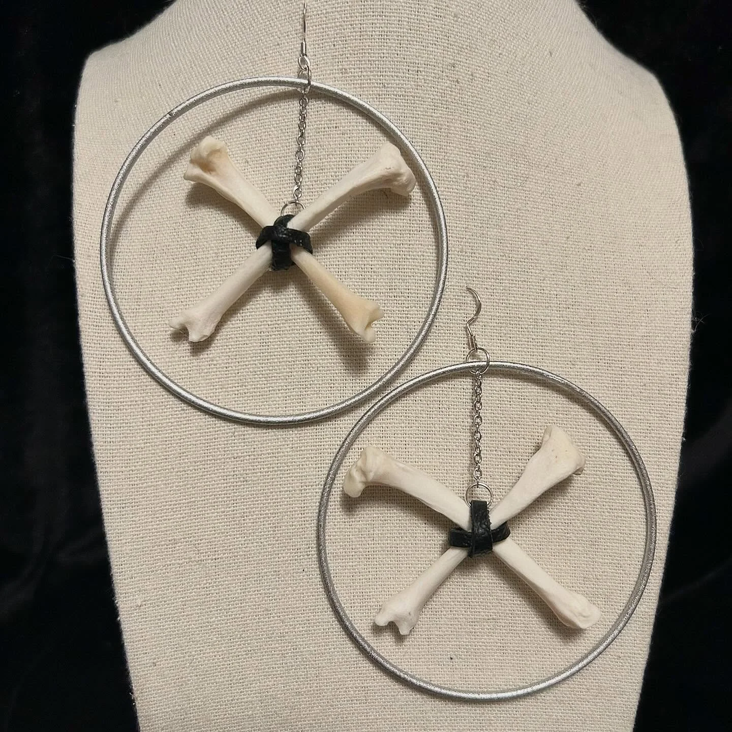 These are a different sort of style for me. X marks the spot with these mink bones which are held together with black leather straps and suspended inside upcycled silver bangles.