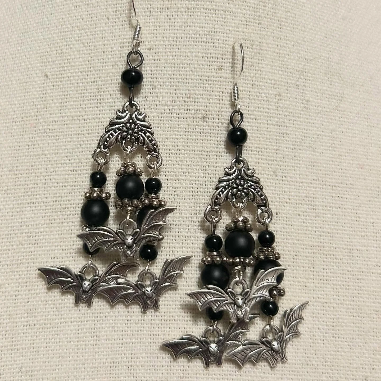 A cute little cloud of bats hang from sparkling crystals and frosted black glass beads.