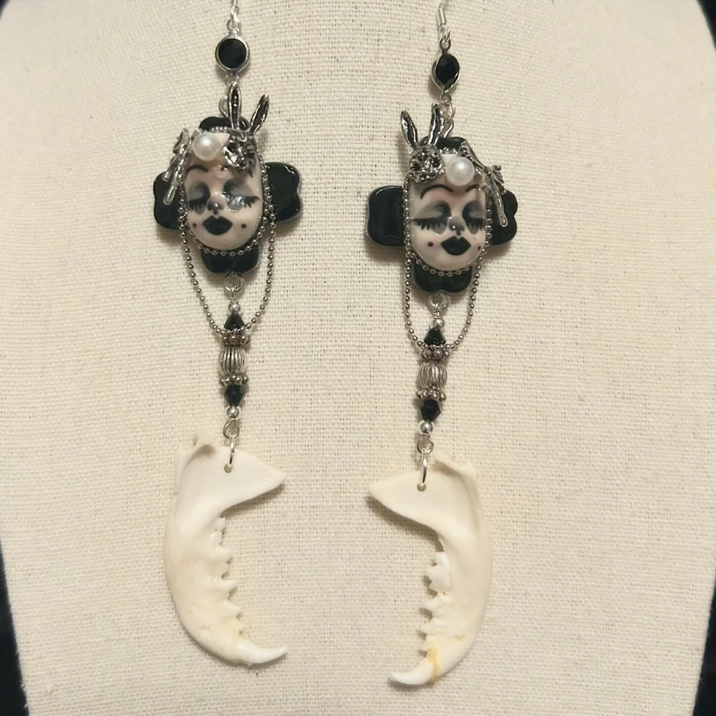 An interesting collage adorns these 2 playful characters. They are combined with upcycled beads and mink jaws.