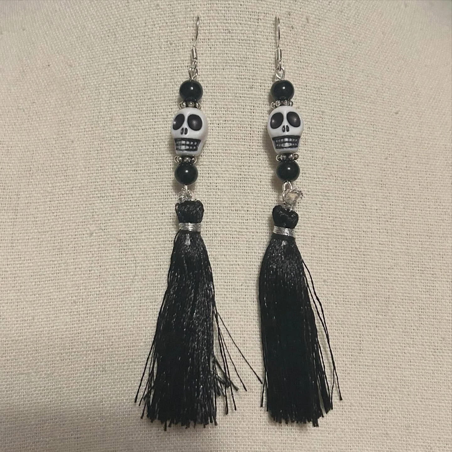 Skull beads with black tassels and silver findings.