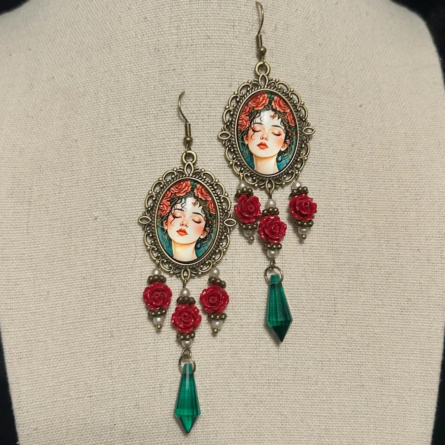Pretty nymph cabochons with red rose beads, faux pearls, and dark green pendants.