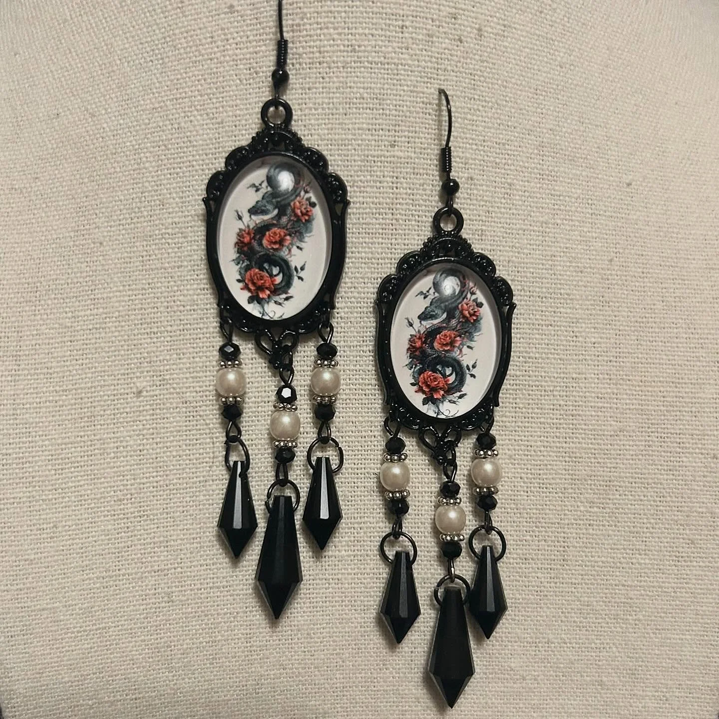 Snake cabochons with faux pearls and black pendants.