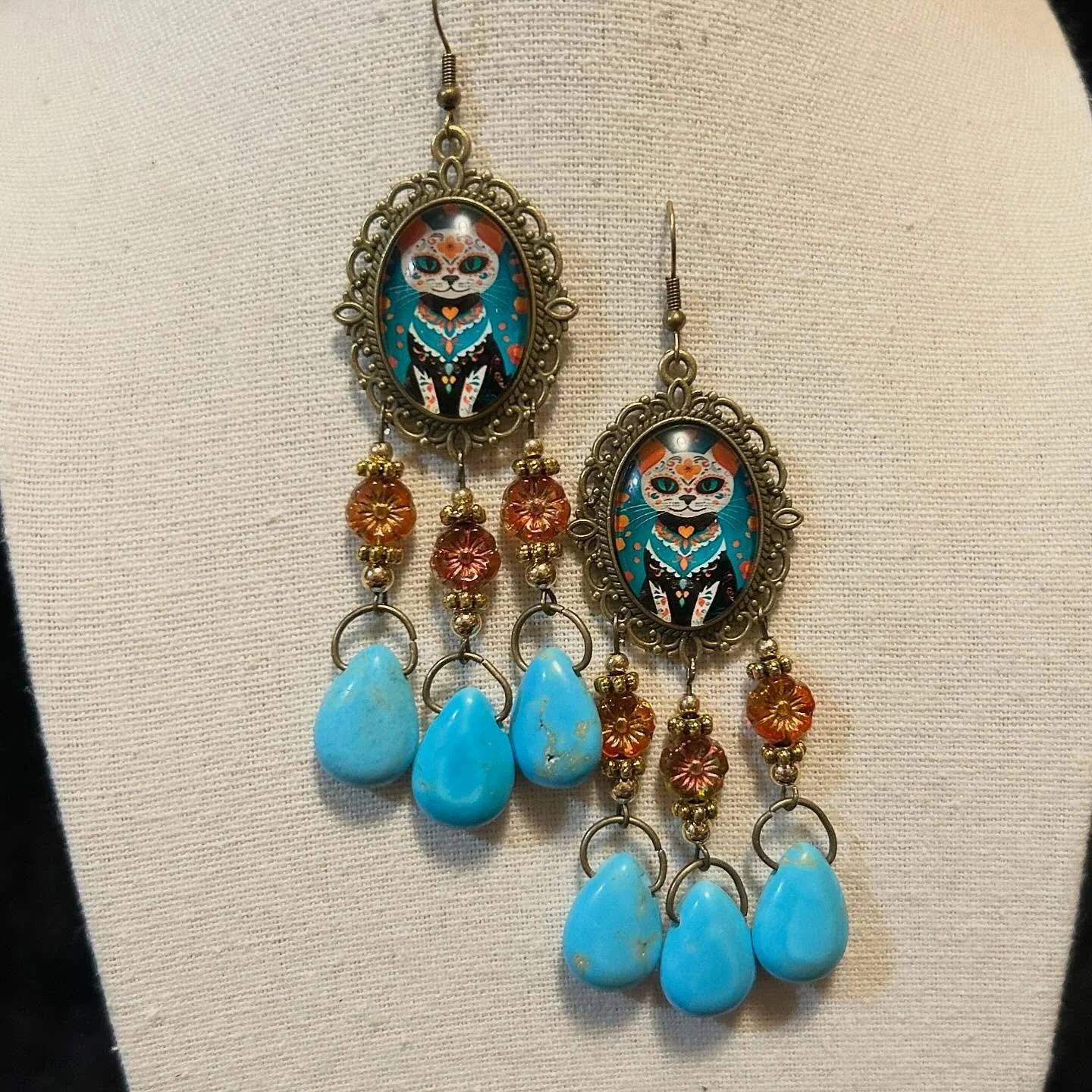Dia de Los Muertos kitty cabochons with marigold beads and turquoise pendants.