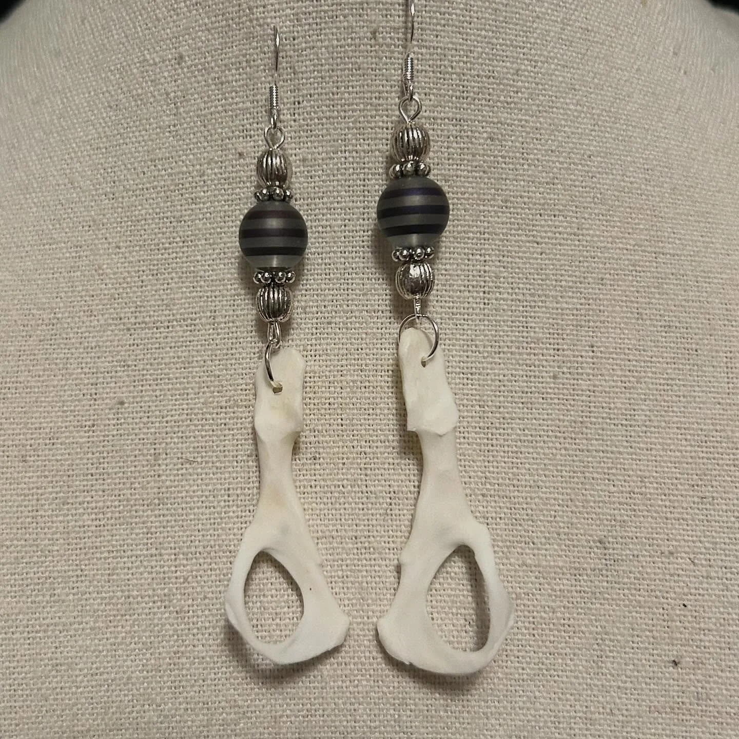 Mink pelvis bones with striped glass and metal beads.