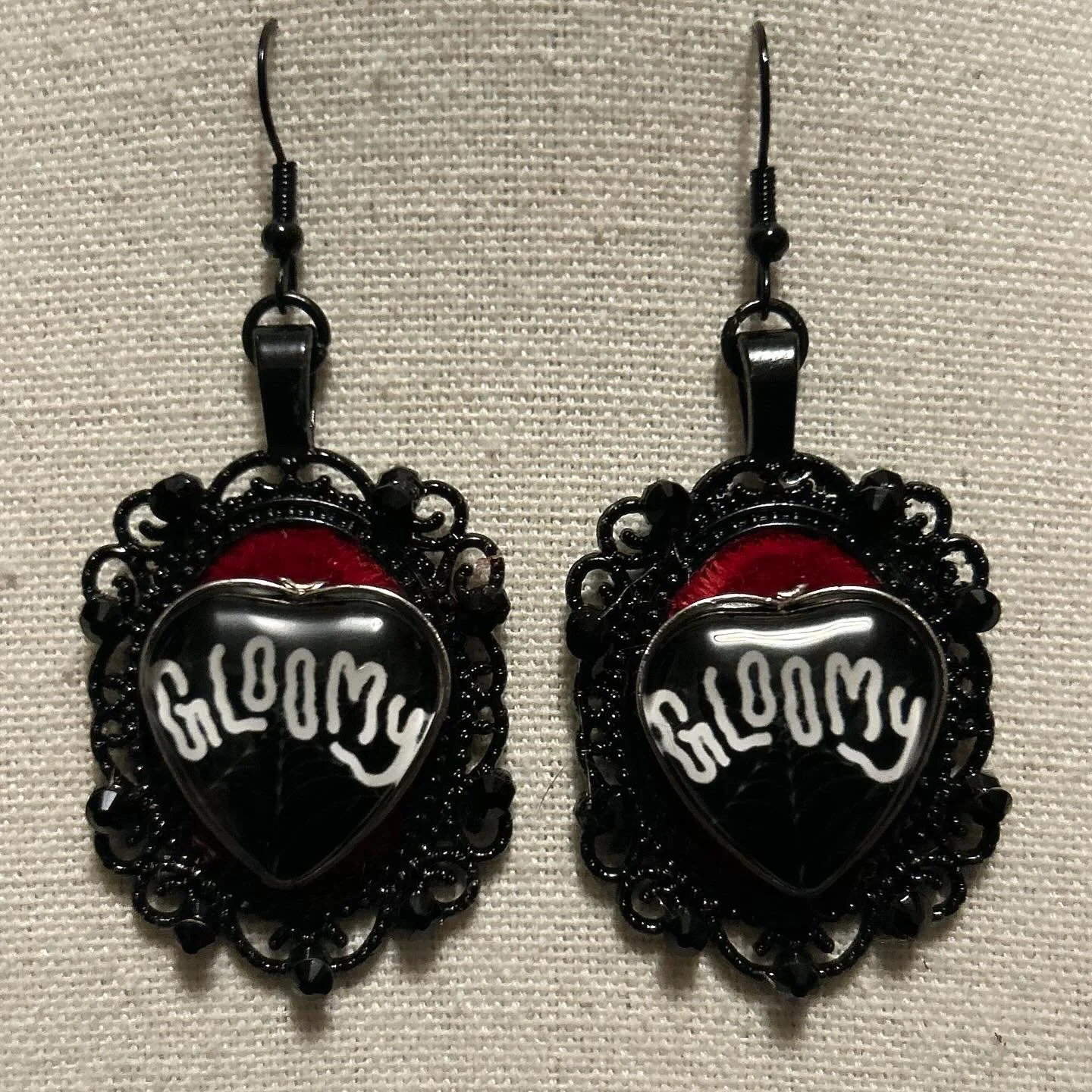 Black hearts with rhinestones on red velvet.