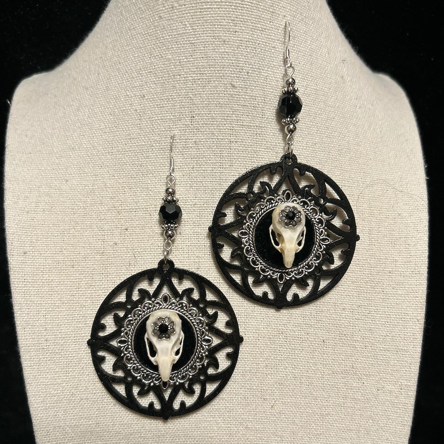 Black wooden backdrop with silver cameo base and mouse skulls.