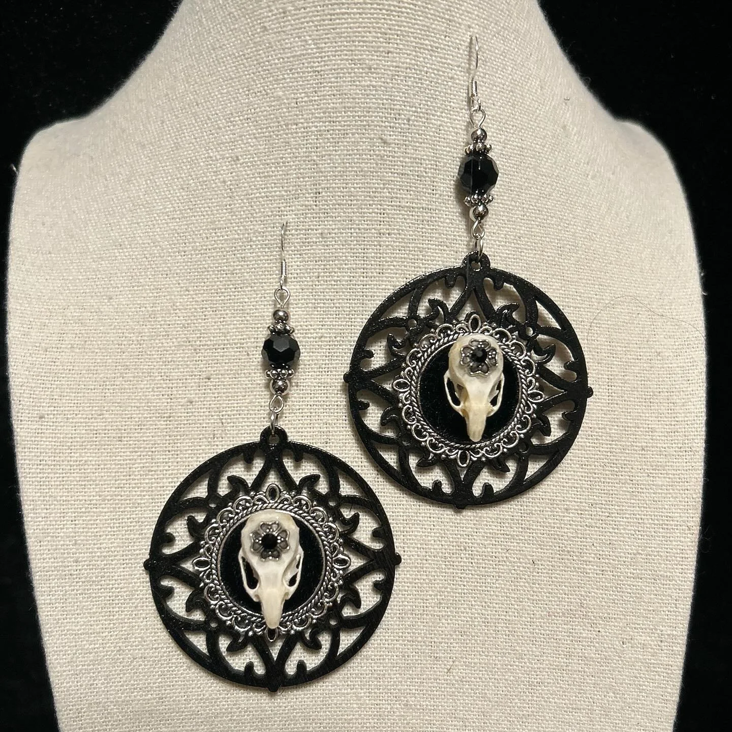 Black wooden backdrop with silver cameo base and mouse skulls.