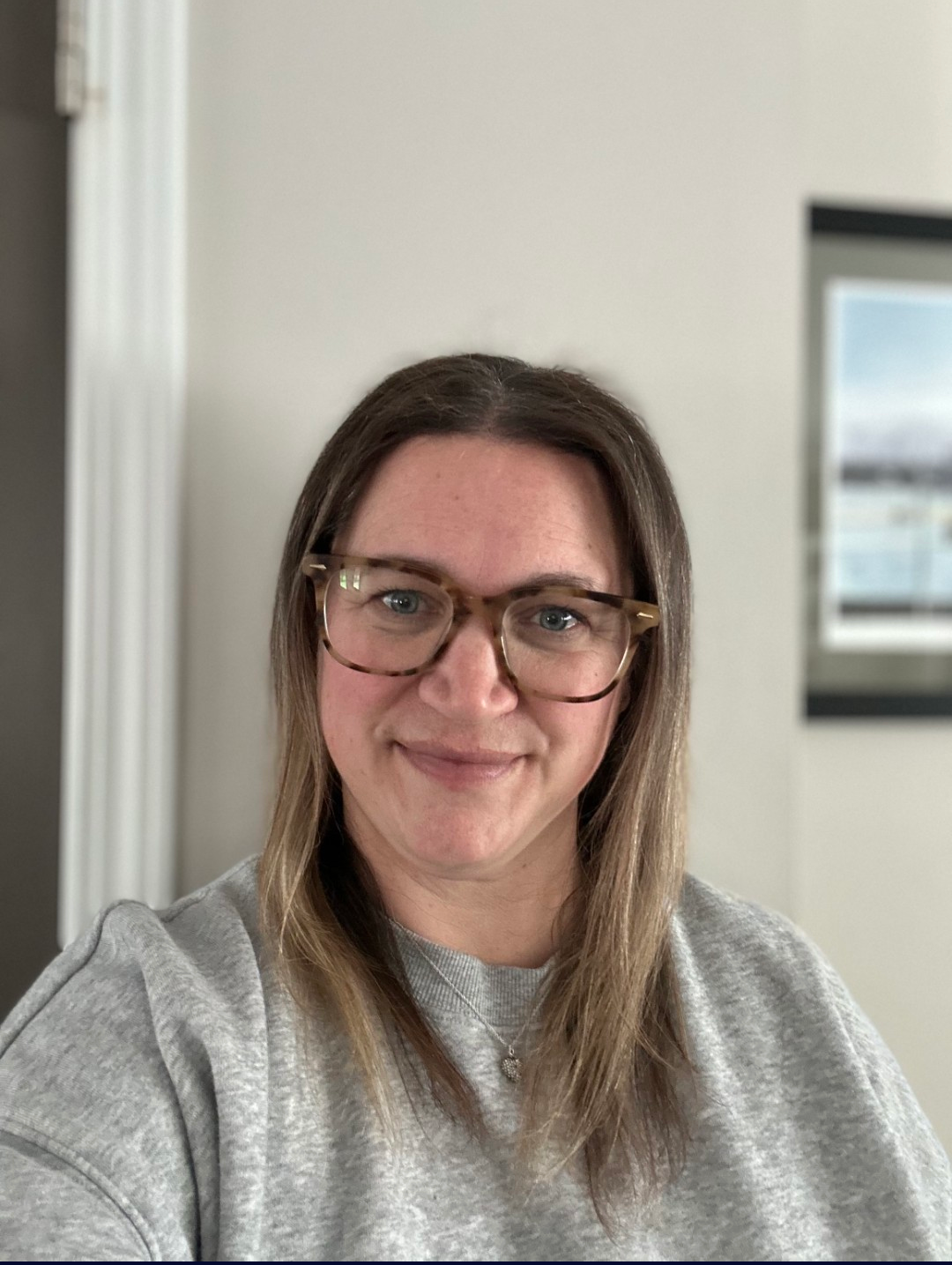 to the side in a room with a plant and artwork in the background.