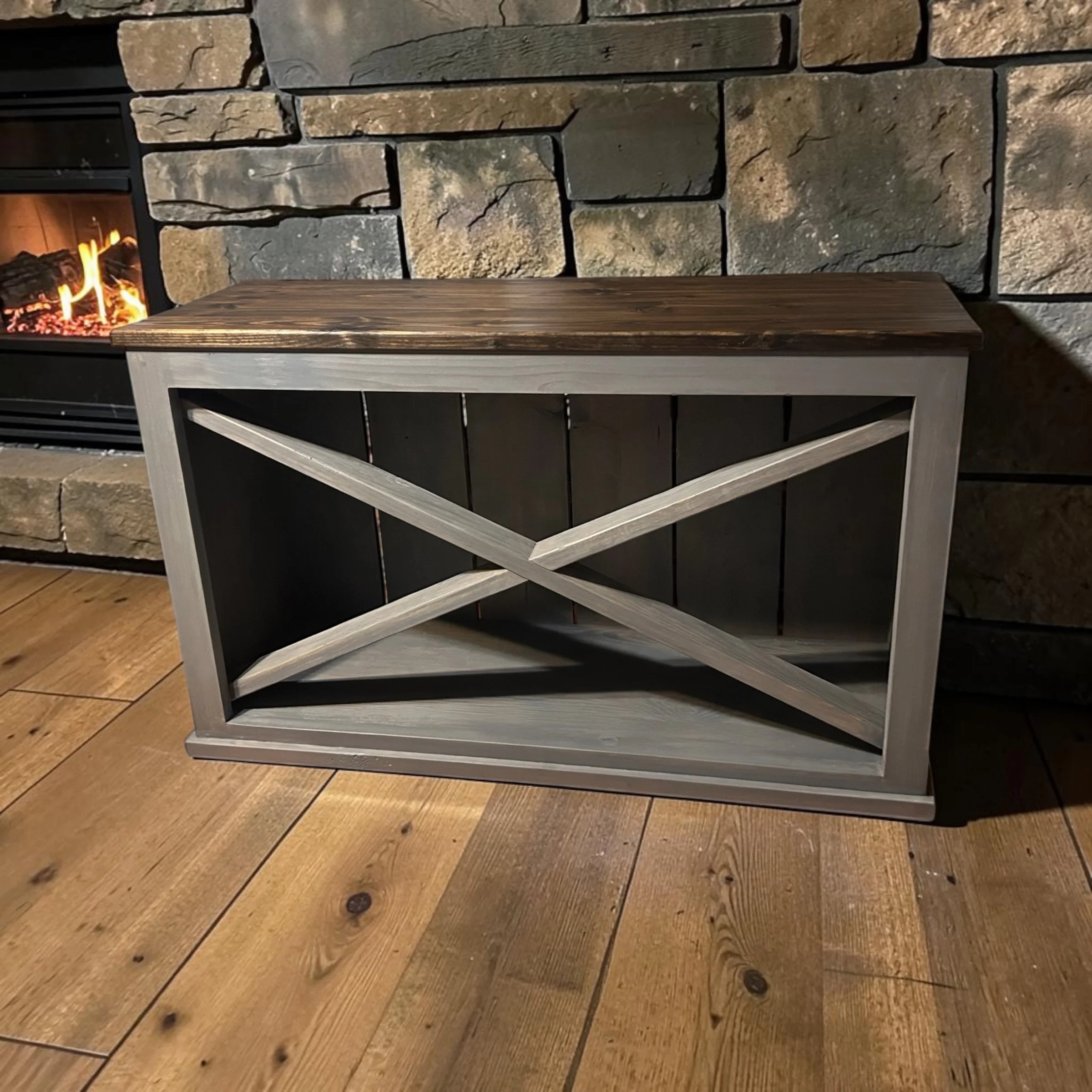 This Hearthside Console pairs a richly toned wood top with a clean, architectural base. Designed to sit comfortably beside a fireplace or within a refined living space, it offers both presence and purpose without excess. The deep, hand-finished surfa