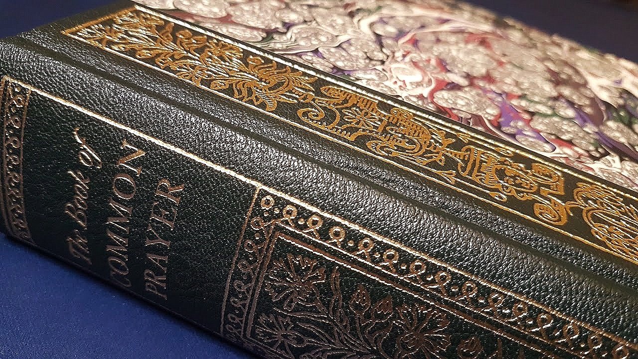 Close-up of an ornate, decorative box with intricate gold designs and floral patterns on the lid, and embossed black leather sides with text that reads 'The Book of Mormon Radicalism'.