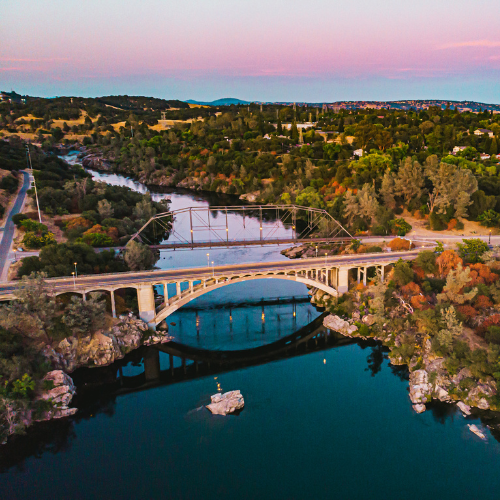 Aerial sunset view of the historic Truss Bridge over the American River in Folsom, CA.