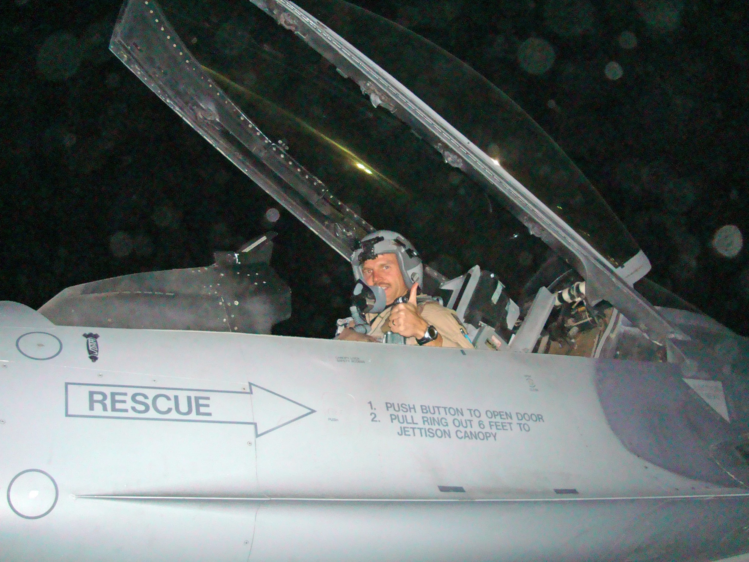Retired Air National Guard F-16 Fighter Pilot James Reeman sits in the cockpit of an F-16 Viper before a combat mission in the middle east. Reeman is wearing his flight helmet, oxygen mask, and night vision goggles.