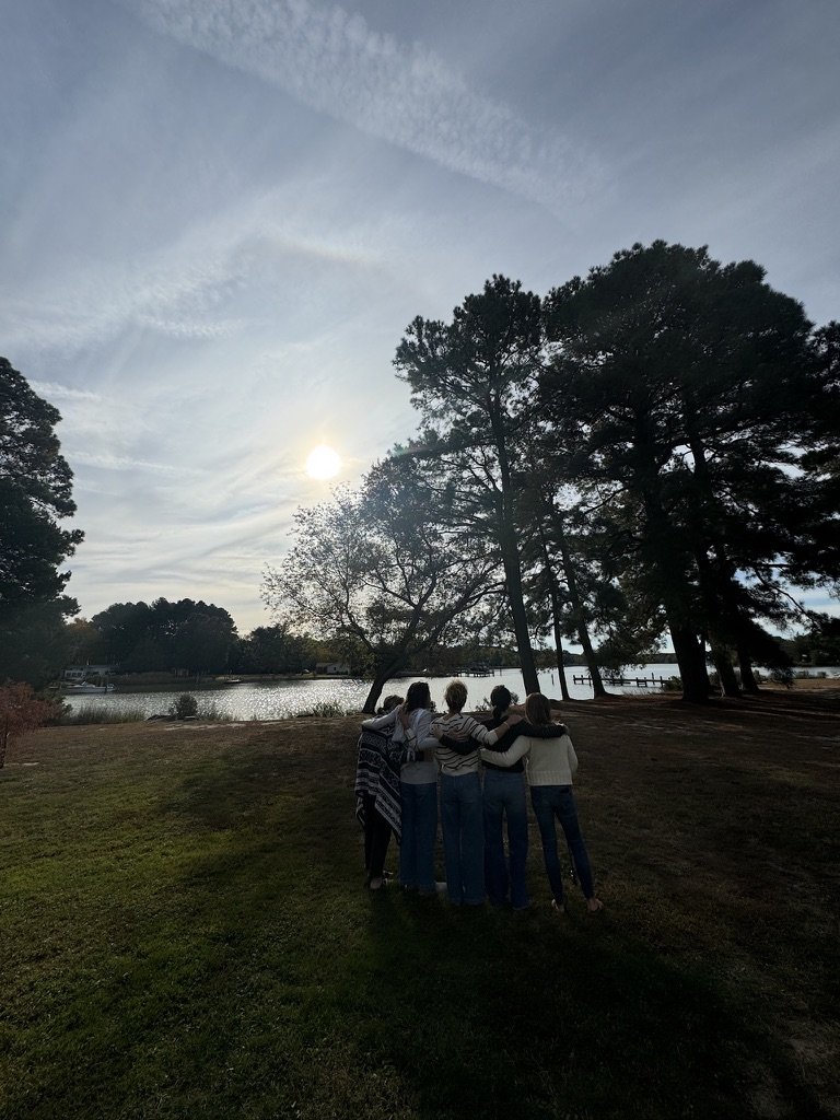 Outdoor wellness or team-building workshop for mission-driven organizations in Nevada – group of participants standing near lake with trees at sunrise or sunset, facilitated by ALIGN Agency