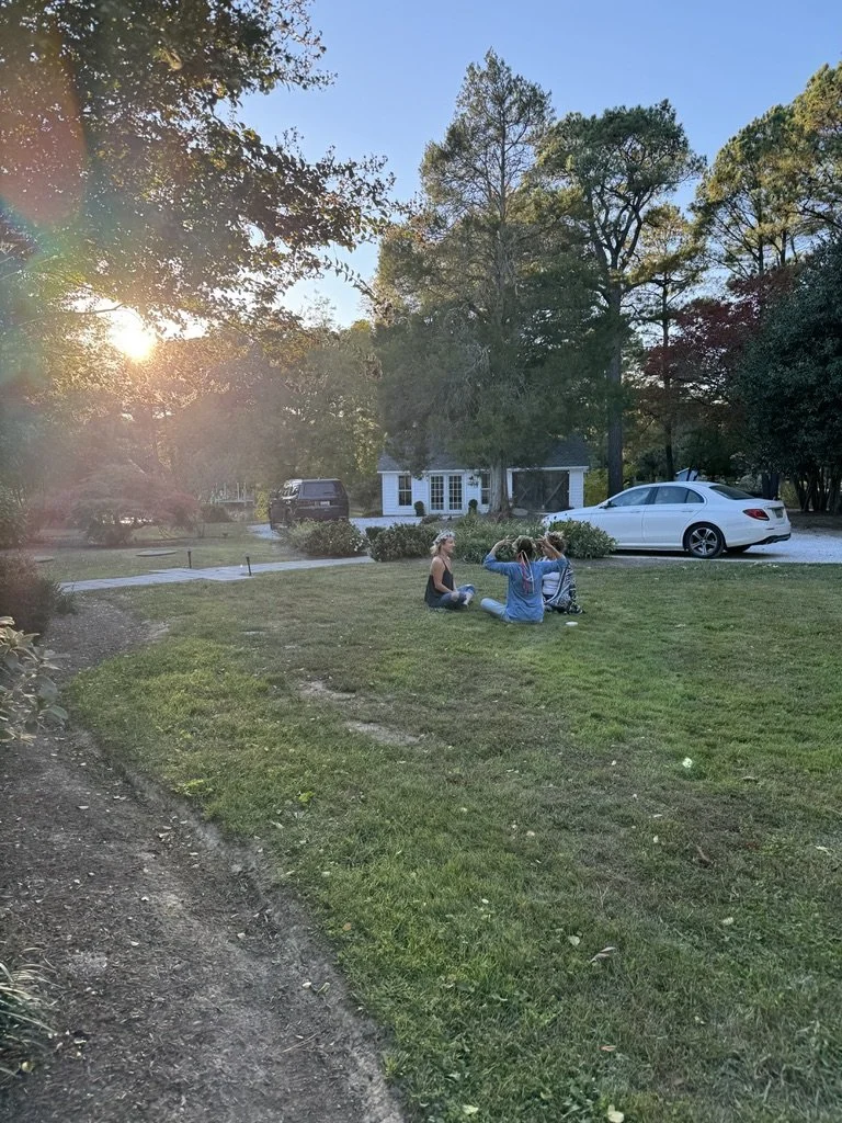 Outdoor community or wellness workshop for mission-driven organizations in Las Vegas – participants sitting on lawn engaged in discussion during sunset, facilitated by ALIGN Agency
