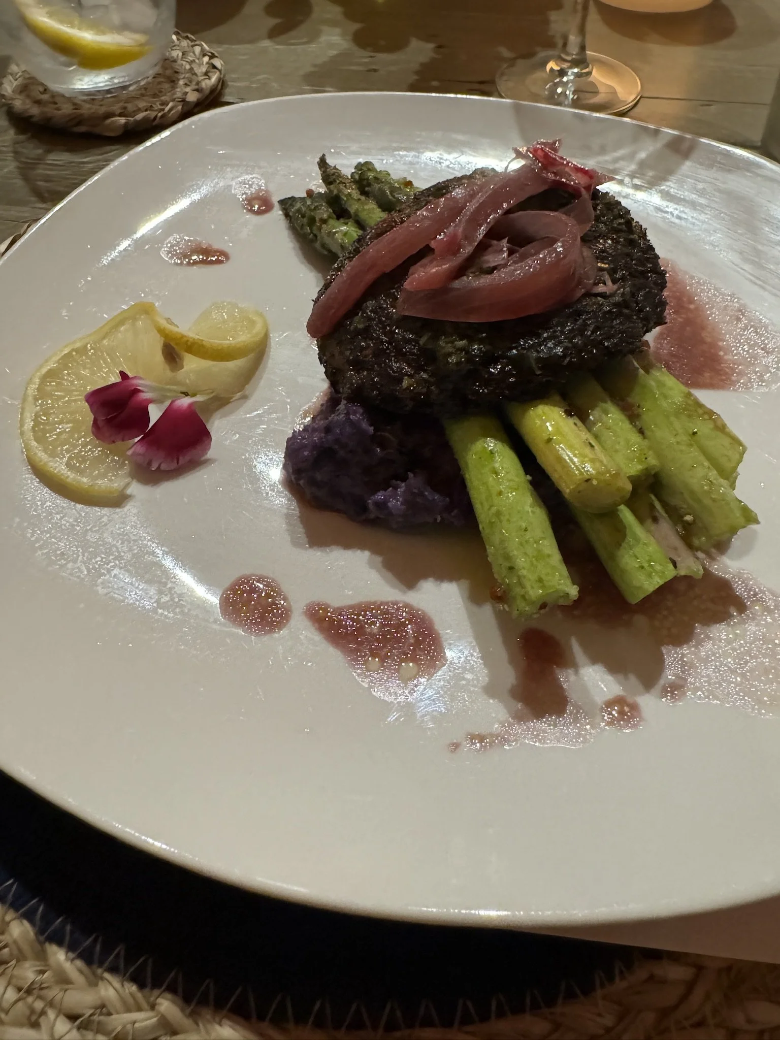 Gourmet plated meal at a wellness or nonprofit event in Nevada – grilled steak with caramelized onions, asparagus, purple mashed side, lemon slices, and edible flower garnish facilitated by ALIGN Agency