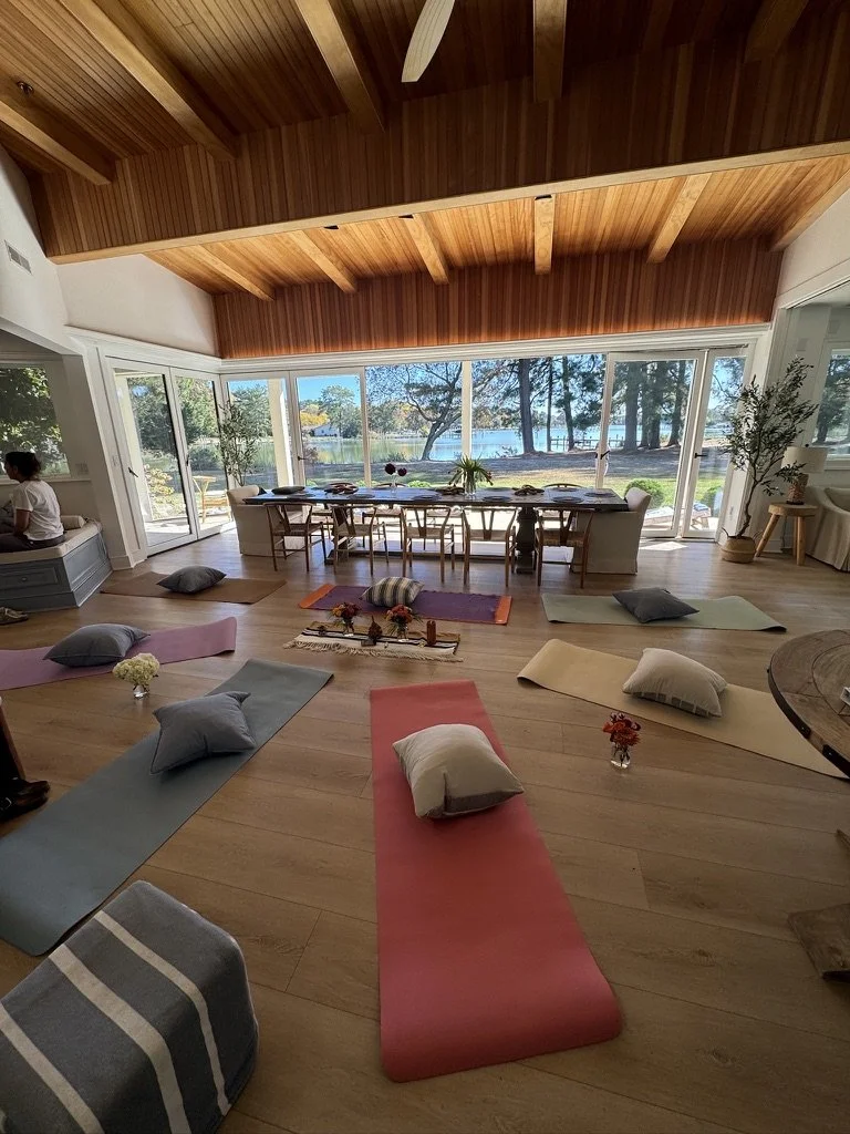 Indoor yoga and meditation space for mission-driven organizations in Nevada – colorful mats and pillows overlooking lake with plants and natural decor, facilitated by ALIGN Agency