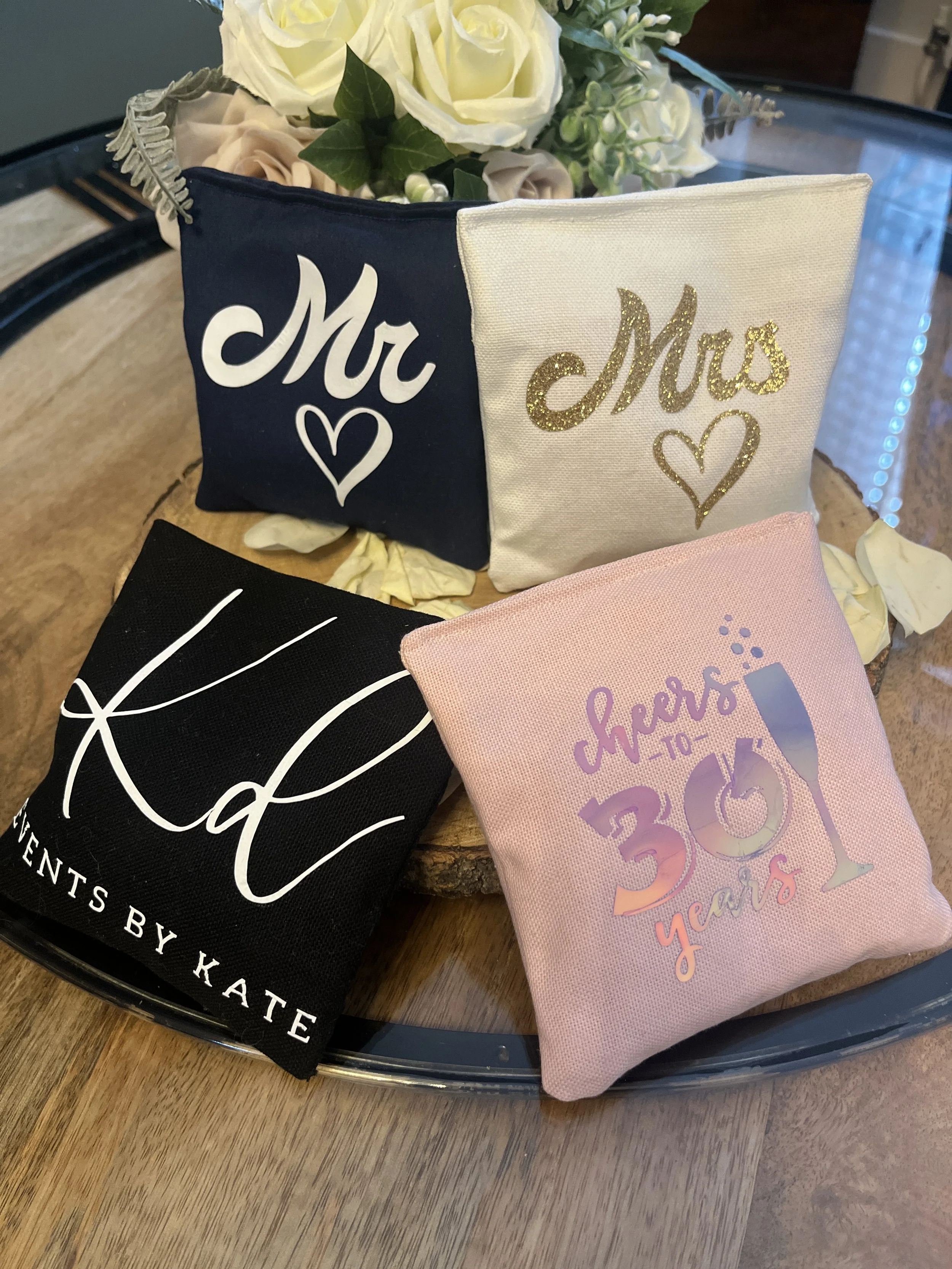 A pyramid of tin cans placed on a tree stump on grass, with a white signboard nearby displaying rules for a game called 'Tin Can Alley'. Forms part of a Giant Lawn Games package.