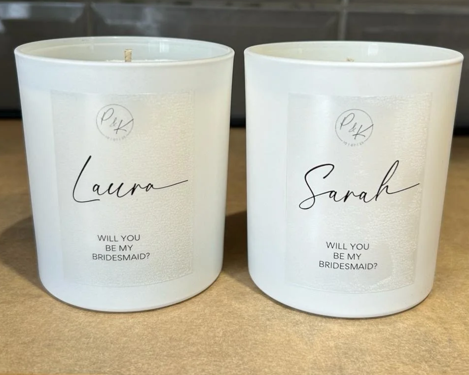 Two white candles with labels reading "Laura" and "Sarah", asking "Will you be my bridesmaid?"