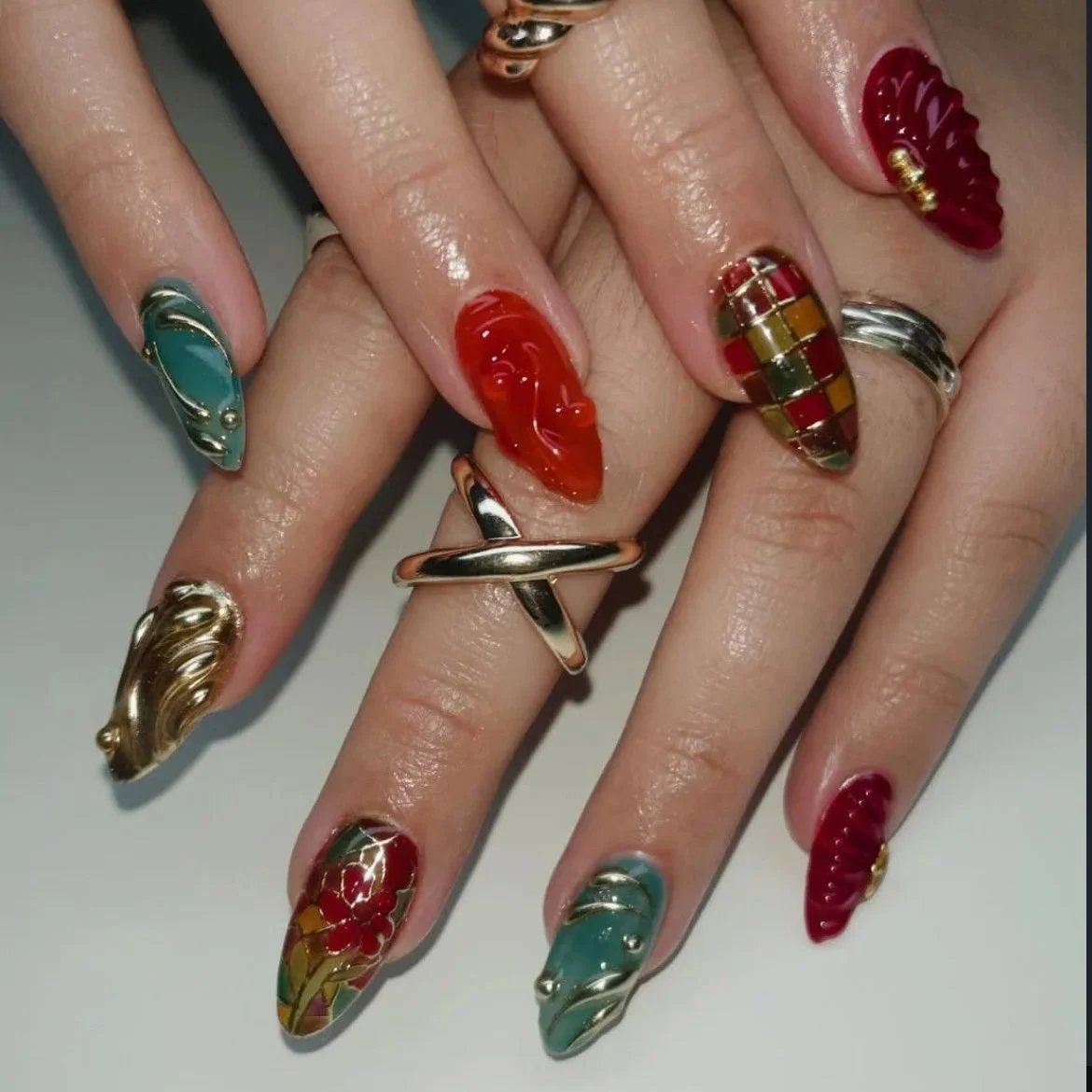 Close-up of hands with colorful, decorated nail art and various rings.